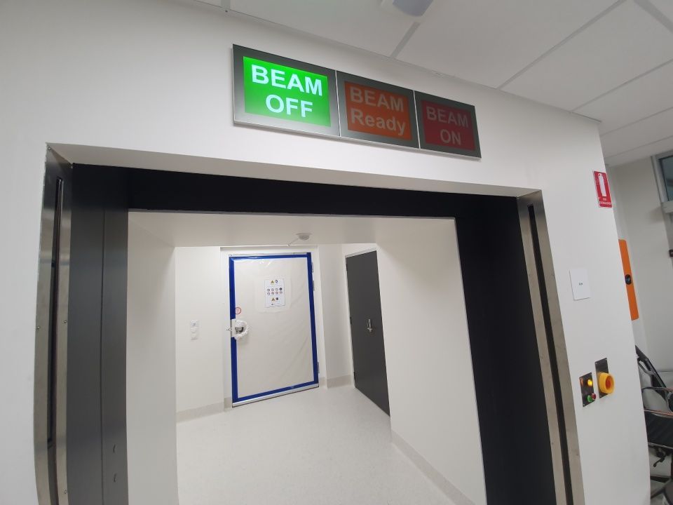 Beam status indicator signage installed at a controlled access entry for medical and commercial facilities