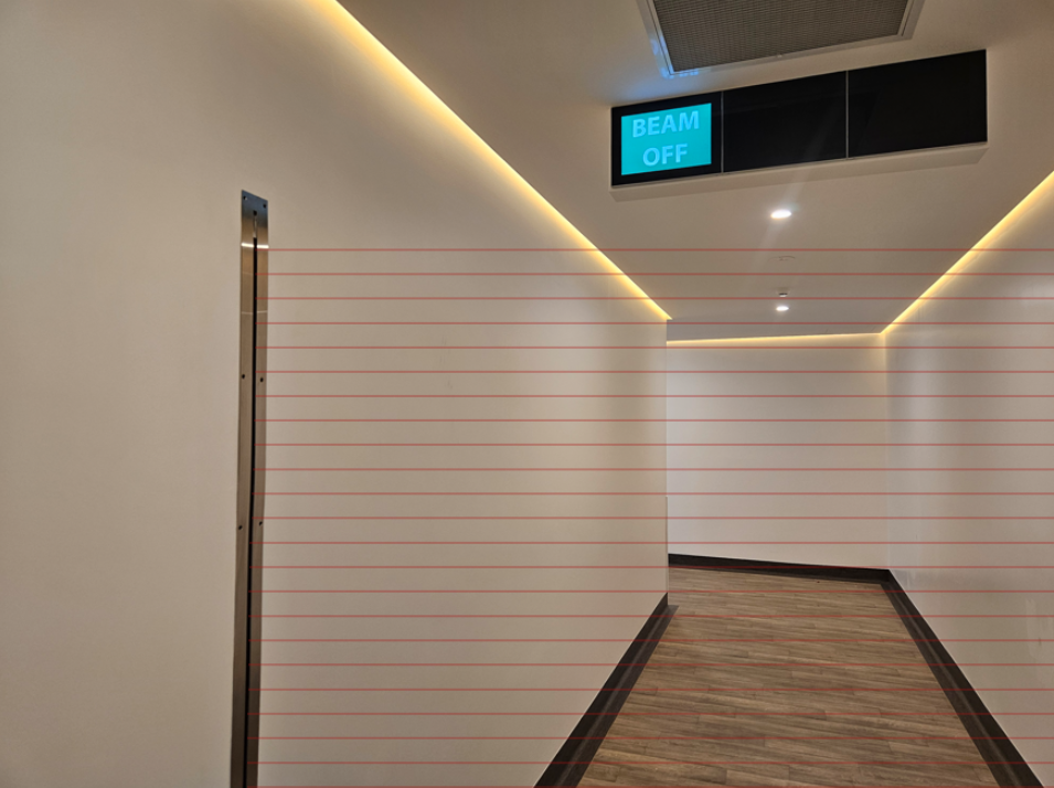 Laser safety curtain installed in a radiation-controlled medical area providing visual warning and access restriction during machine operation