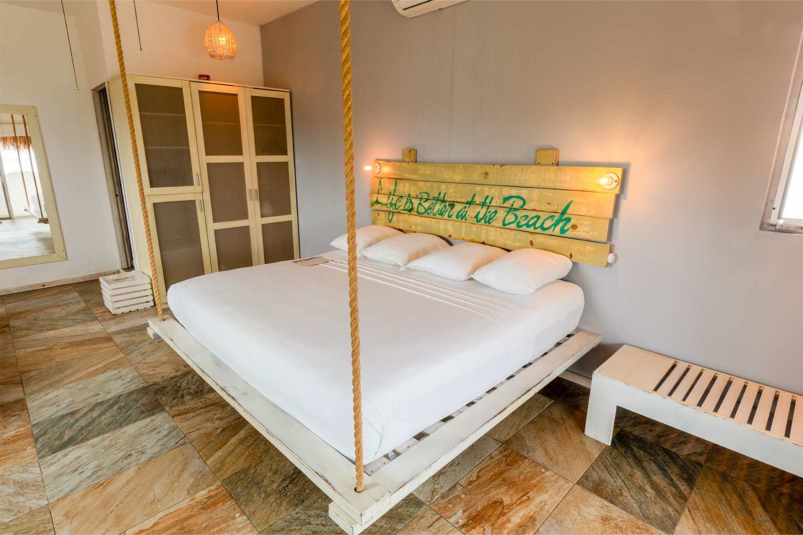 Habitación acogedora con una cama con dosel blanca, suelo de madera rústica y un cartel de 