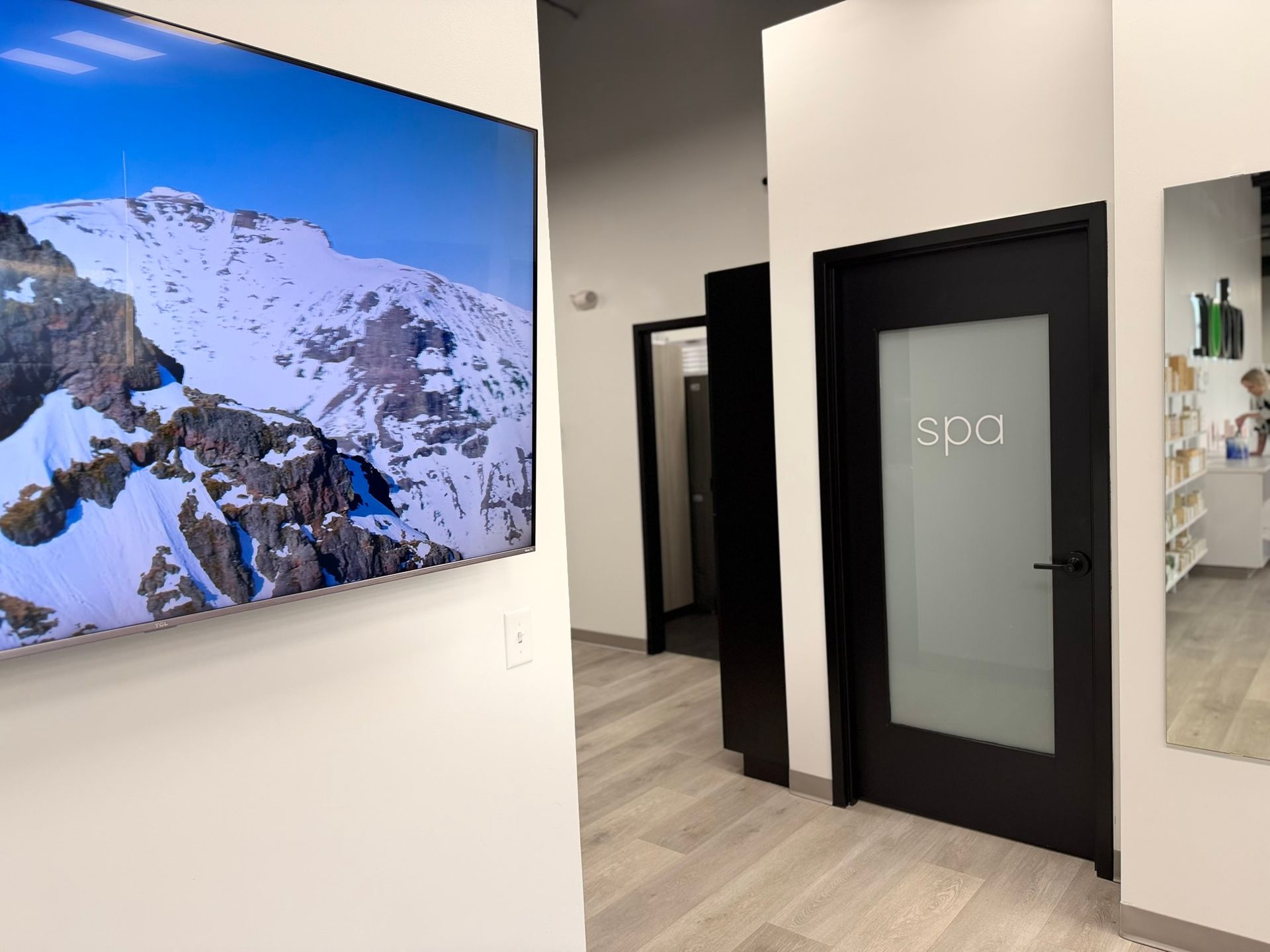 Interior hallway with a mountain scene on a large TV and a door labeled 