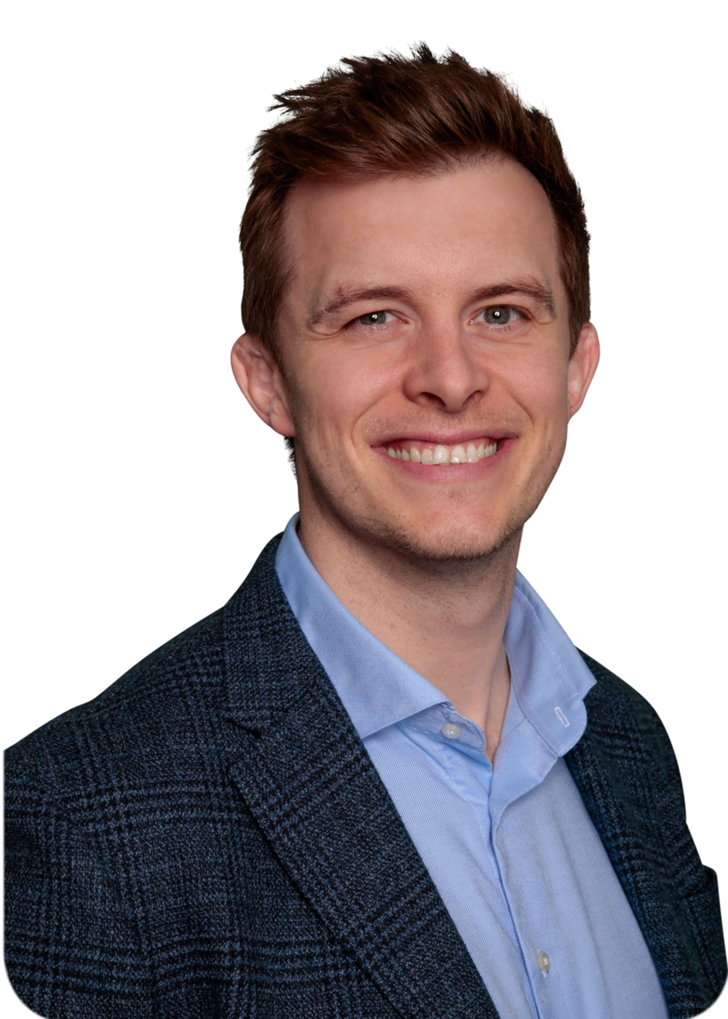 A person with short brown hair smiling while wearing a light blue dress shirt and a dark textured blazer.