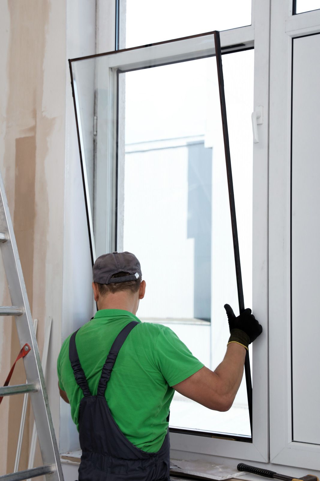 A man is installing a new window in a room.