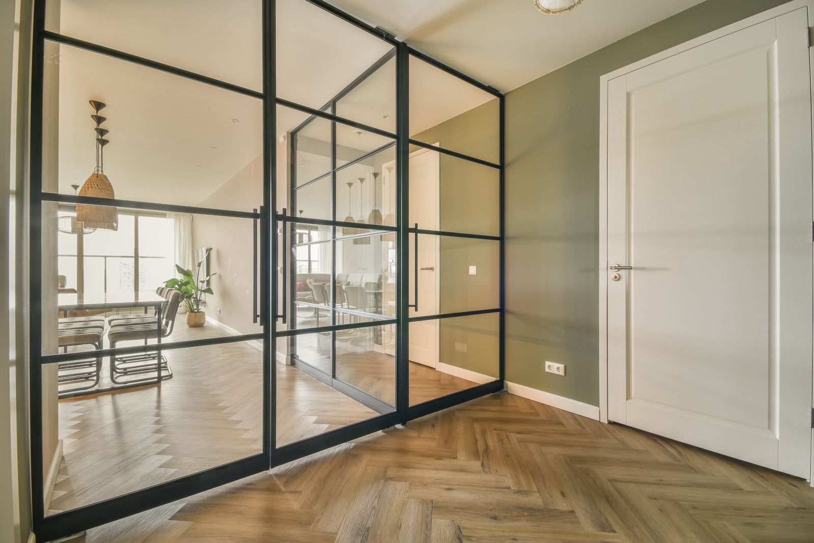 A hallway with sliding glass doors leading to a living room and dining room.