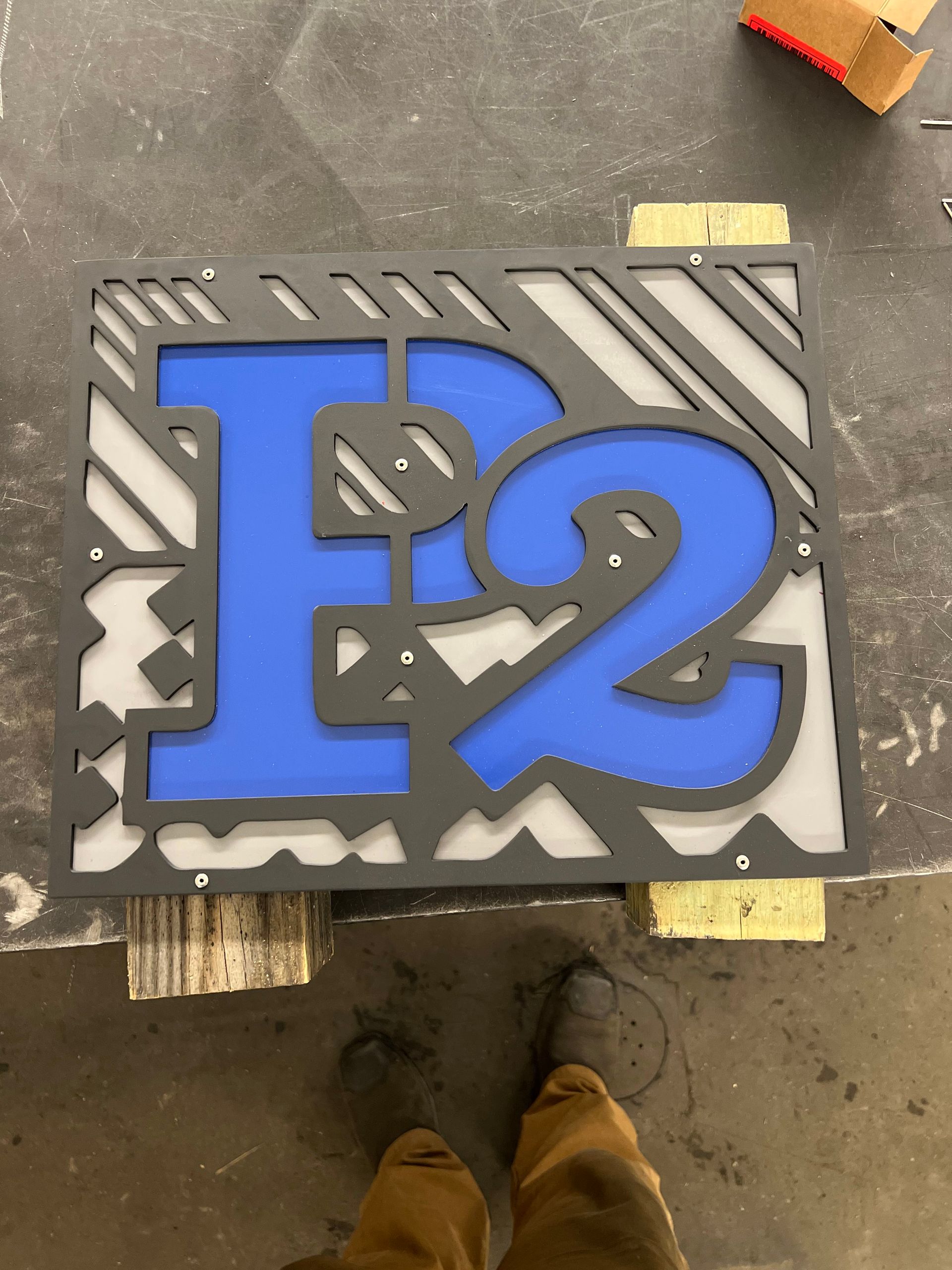 A layered sign featuring a large blue