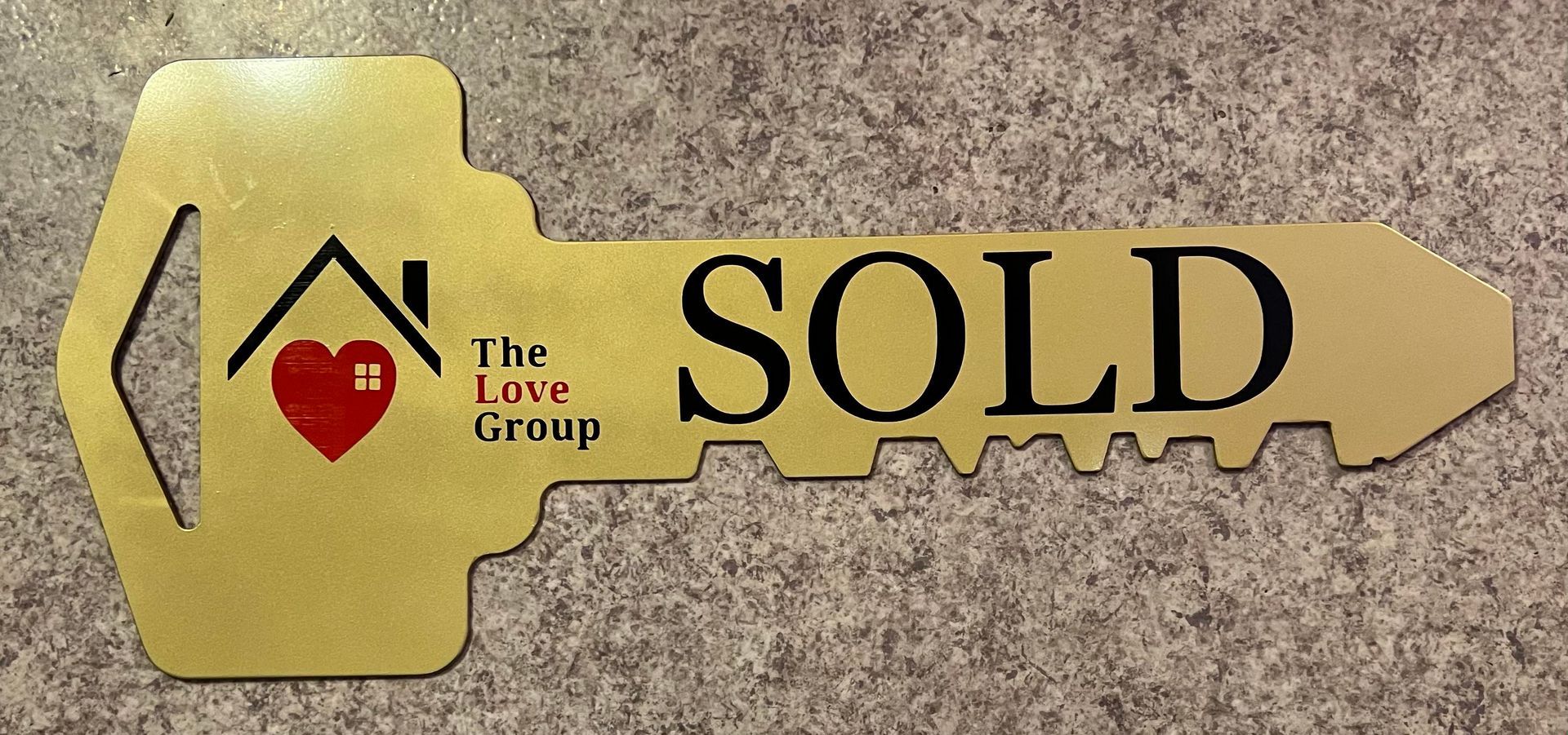 A gold-colored, key-shaped sign labeled