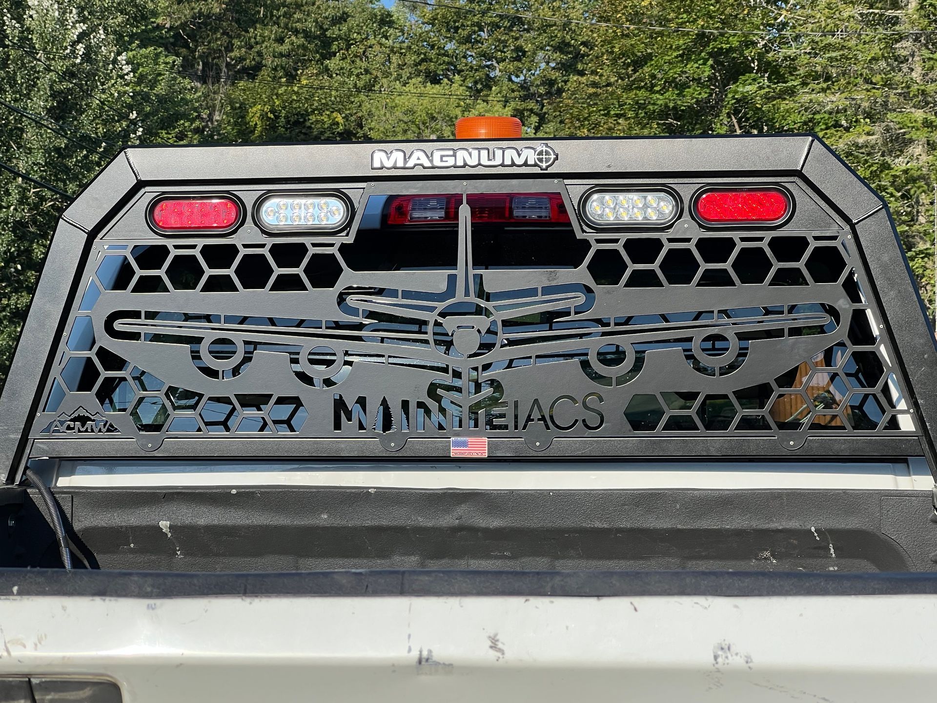 A black metal truck headache rack featuring a laser-cut B-52 bomber silhouette, honeycombed steel, and integrated lights.