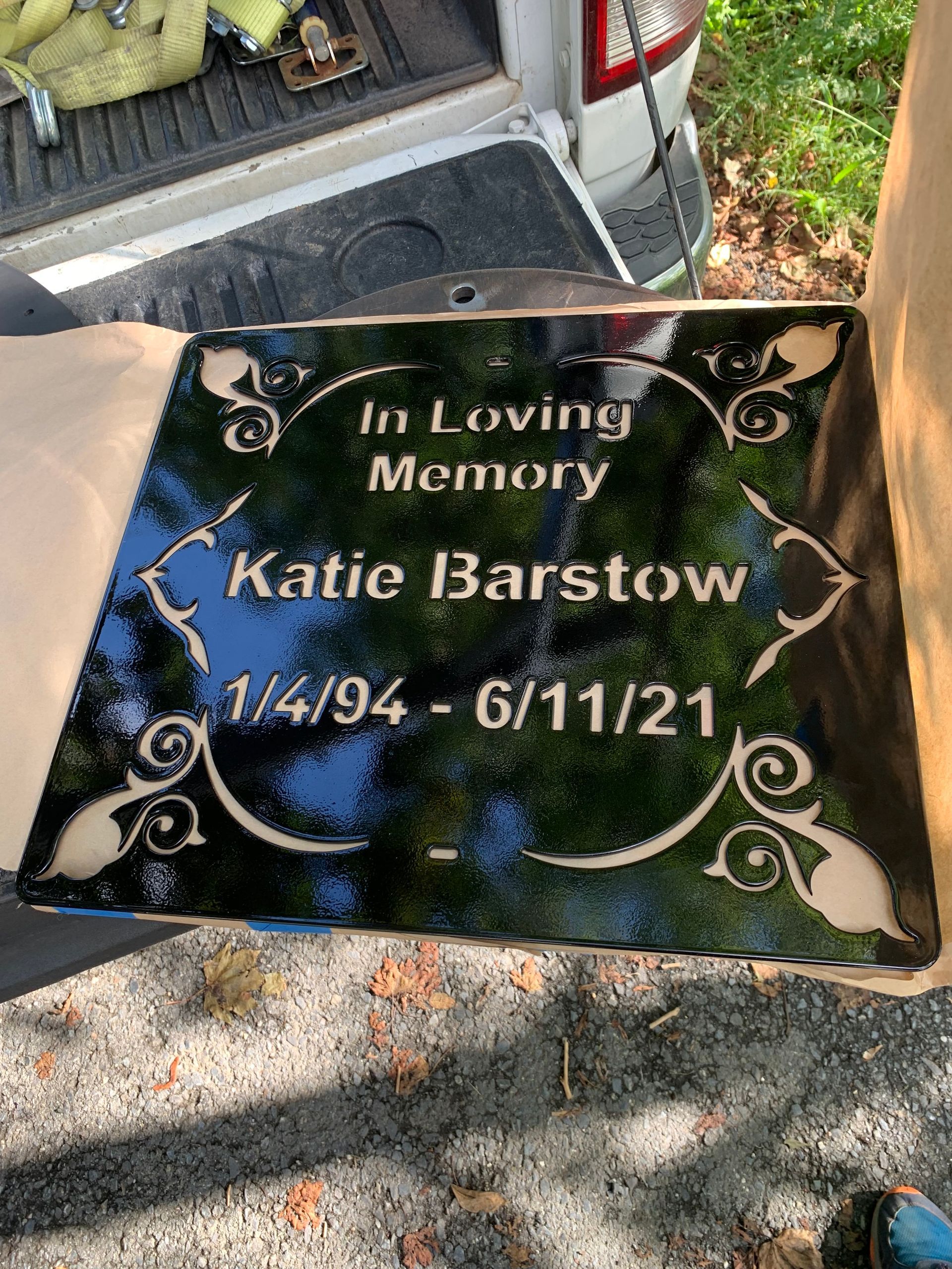 A black memorial plaque with gold lettering,
