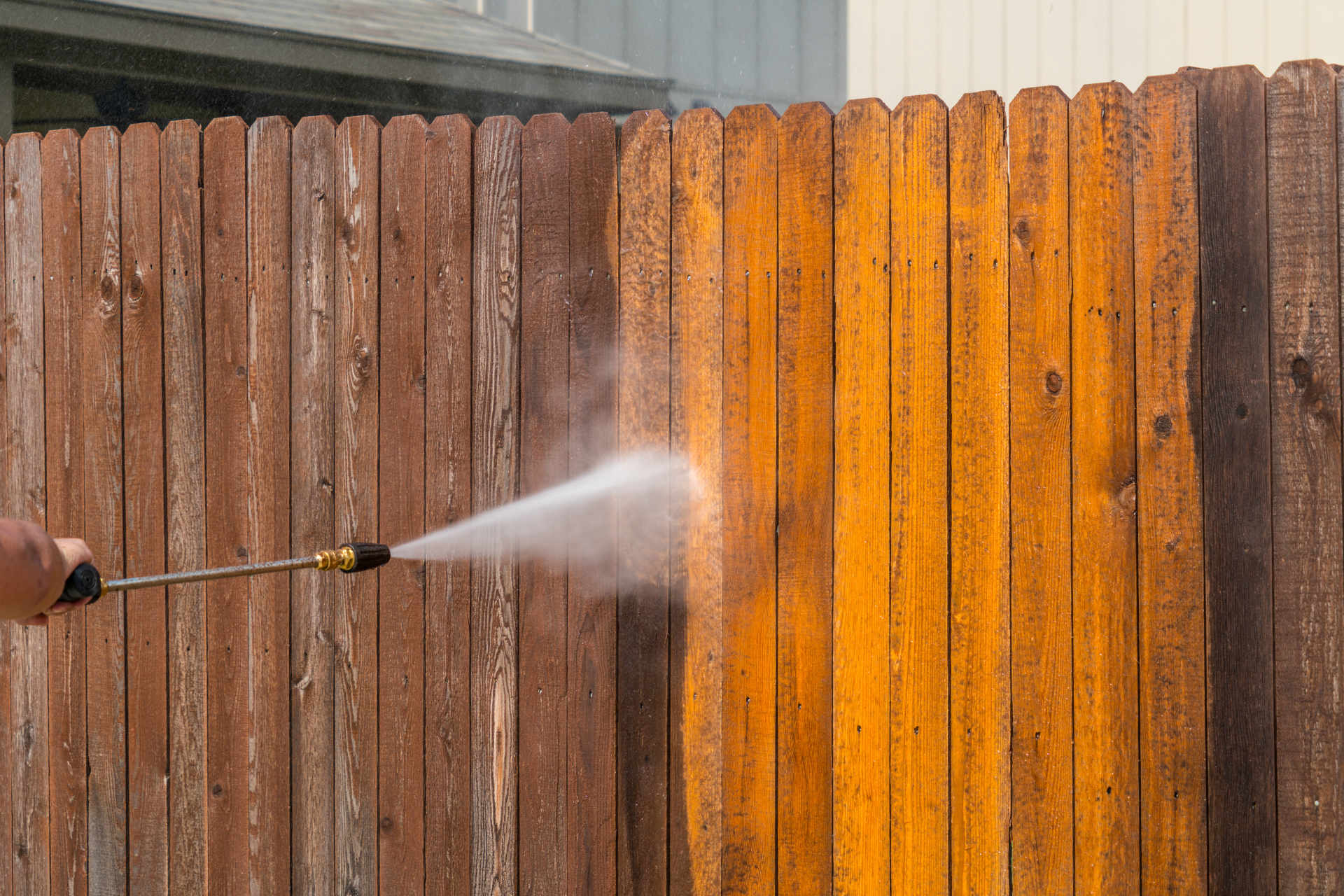 Pressure washing a wooden fence, cleaning the old stain.