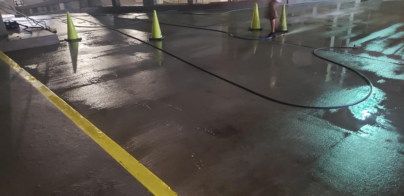 High pressure washing removing dirt buildup from parking lot