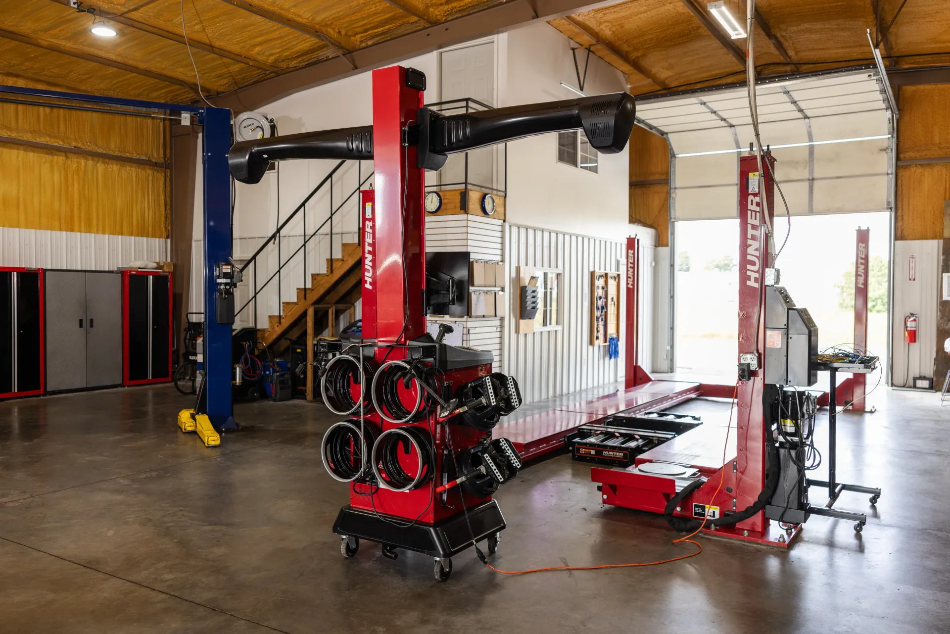 Auto Repair Shop with Red Vehicle Lifts | Craig Automotive Services