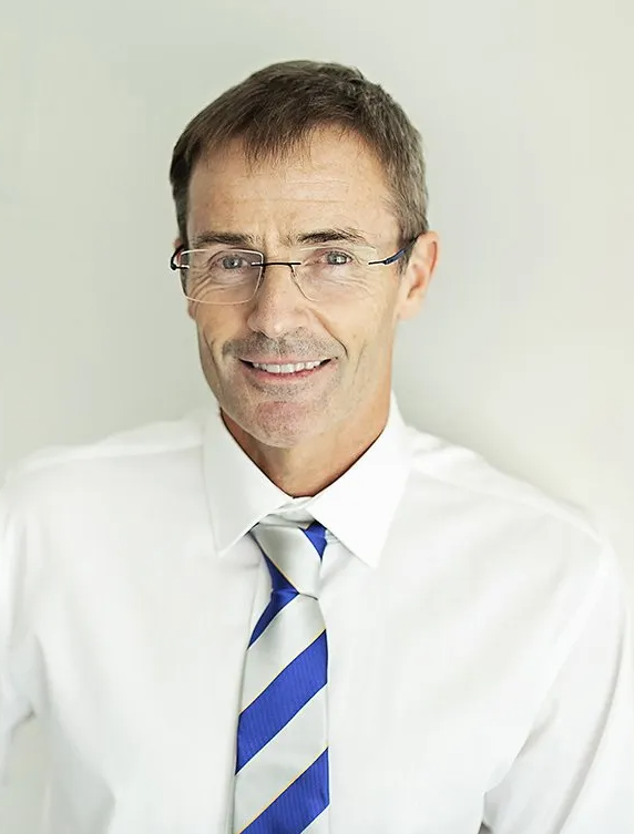 A man wearing glasses and a blue and white striped tie