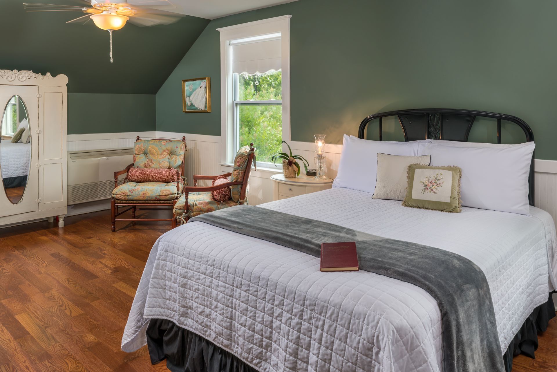 There is a bed in the middle of the room with a book on it.