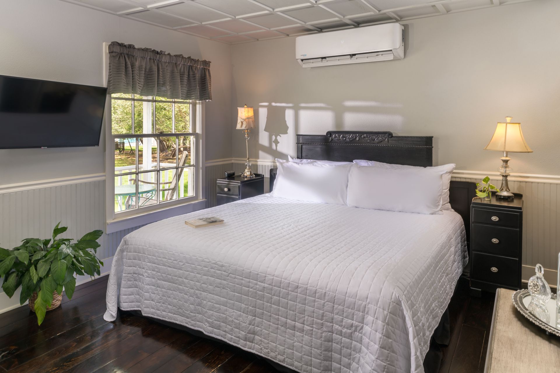 A bedroom with a king size bed and a flat screen tv.