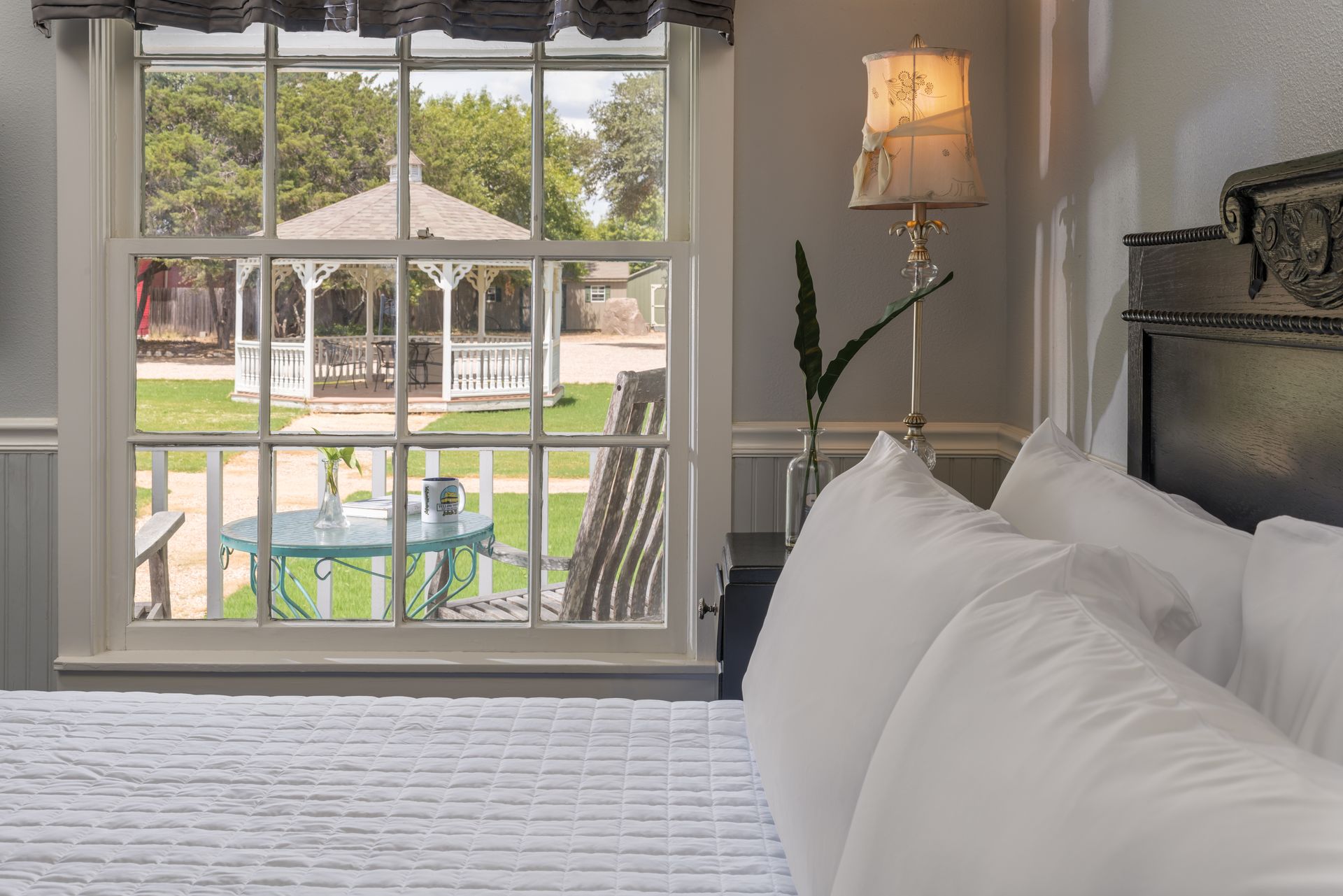 A bedroom with a bed and a window with a gazebo in the background.
