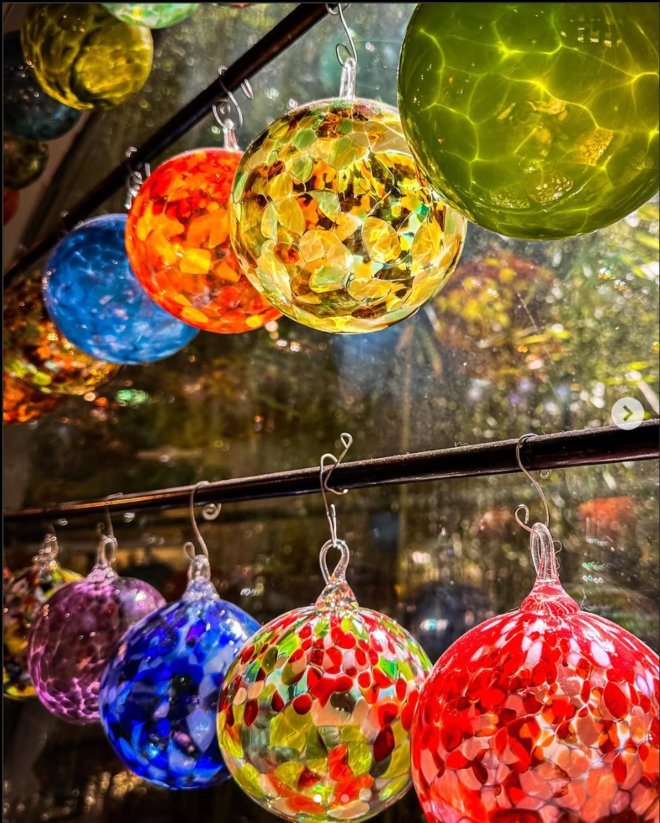 A bunch of colorful glass ornaments hanging from a wire