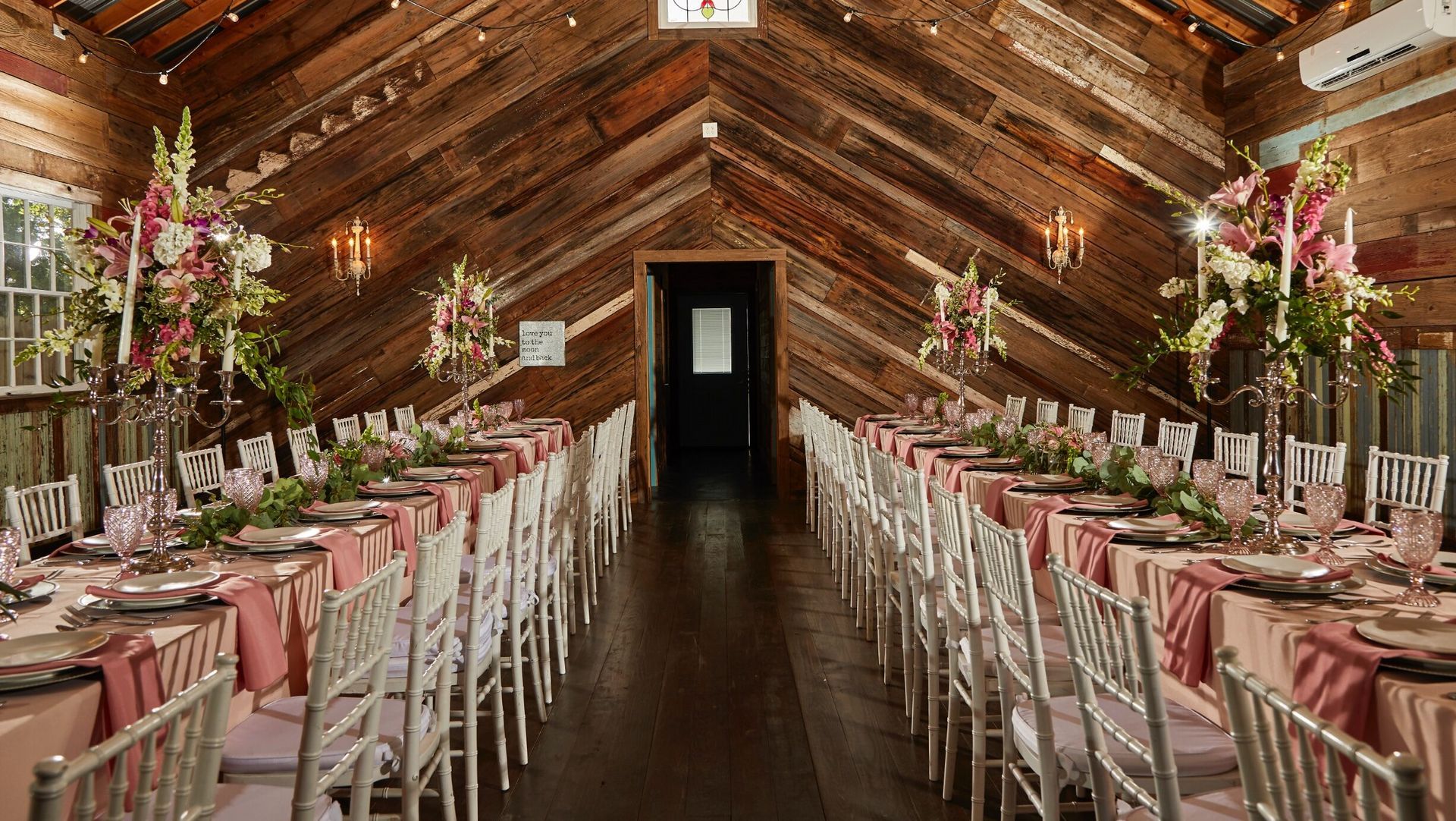 A long hallway with tables and chairs set up for a wedding reception.