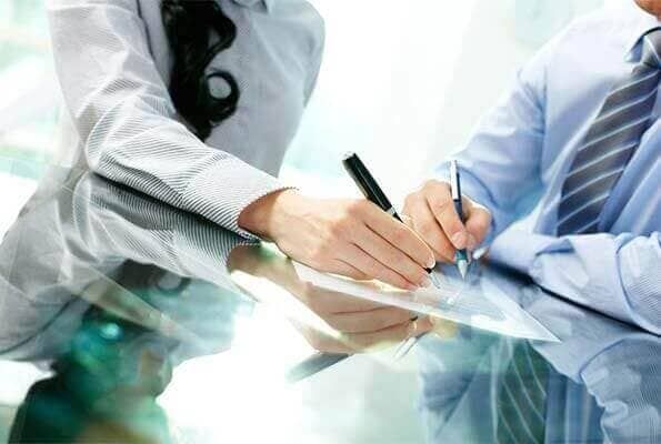 Un hombre y una mujer firman un documento.
