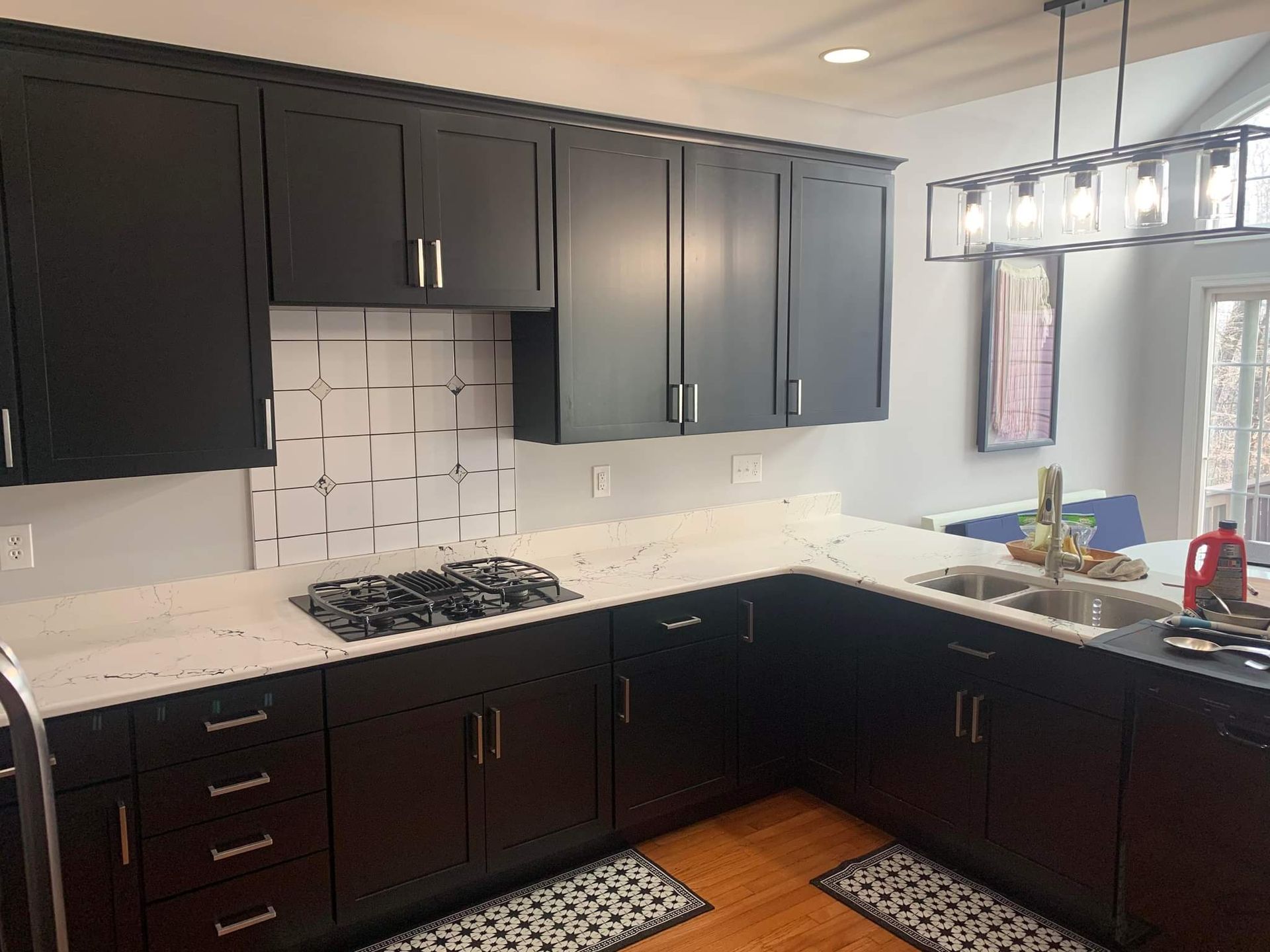 A kitchen with black cabinets and white counter tops.
