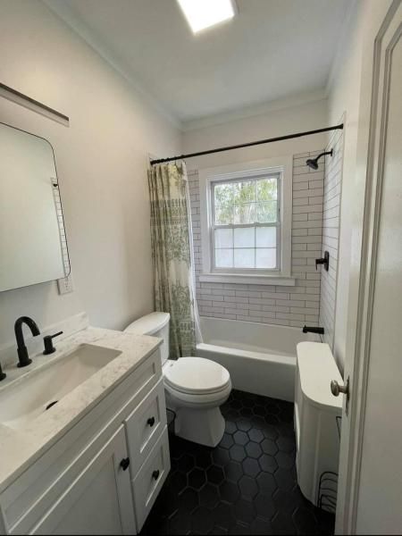 A bathroom with a toilet a sink and a tub