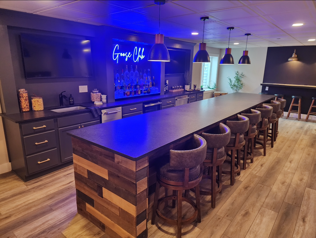 A kitchen with a long counter and stools.