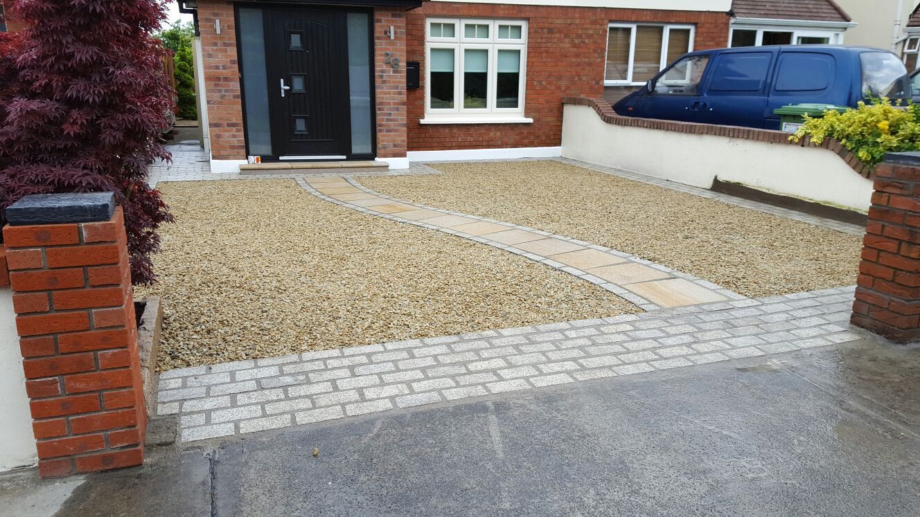 Gravel driveway with brick edging and pathway leading to a black front door, flanked by brick pillars.
