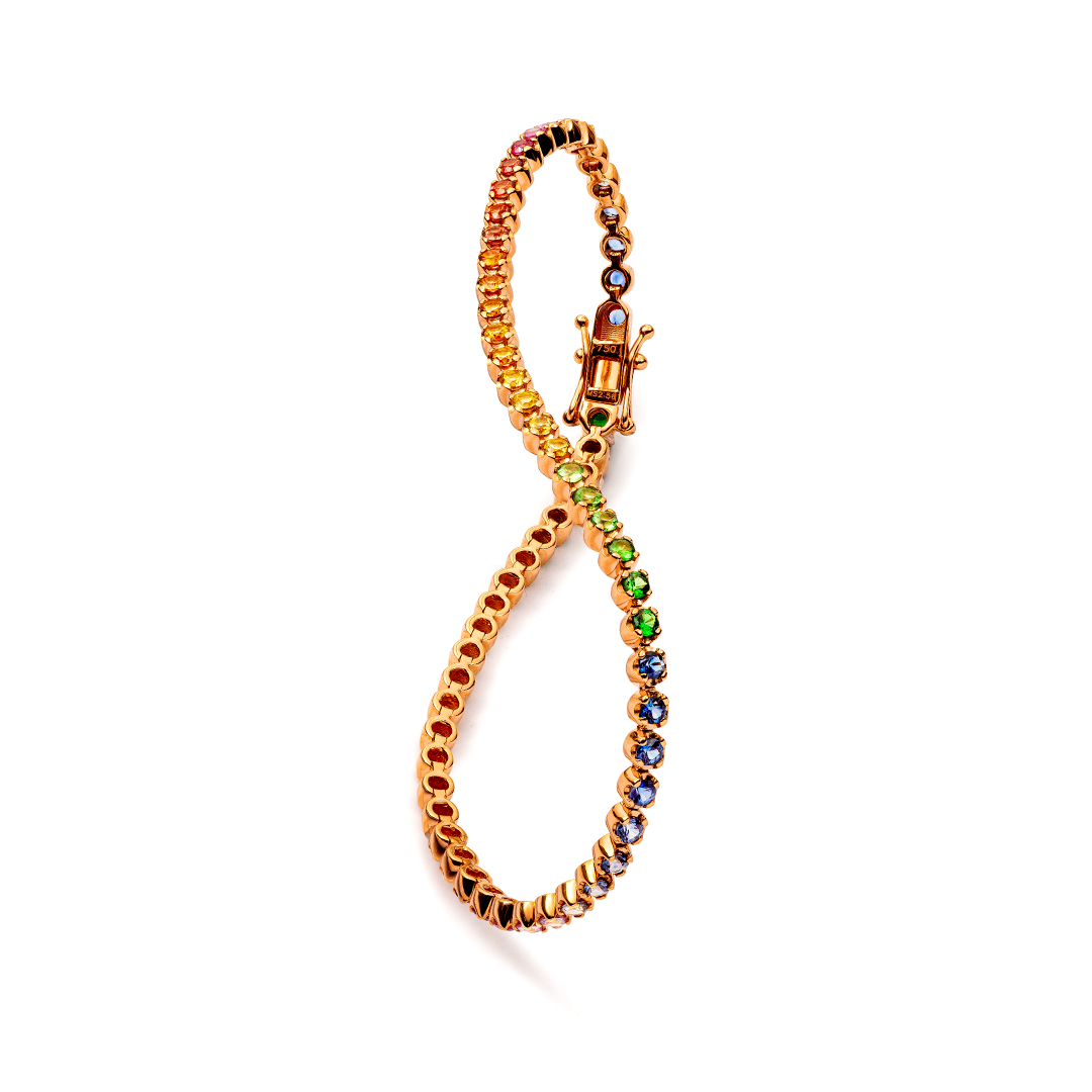 ein goldenes Armband mit regenbogenfarbenen Steinen auf weißem Hintergrund