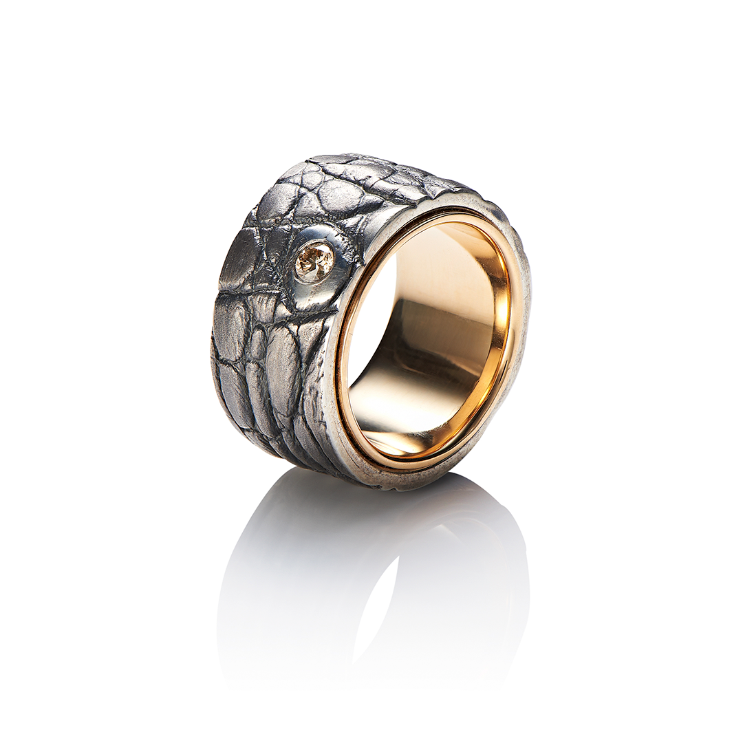 ein Ring aus Silber und Gold mit einem Diamanten in der Mitte