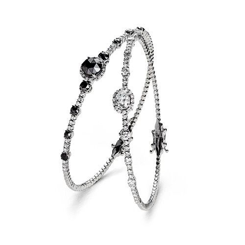 ein Paar Armbänder mit schwarzen und weißen Diamanten auf weißem Hintergrund.