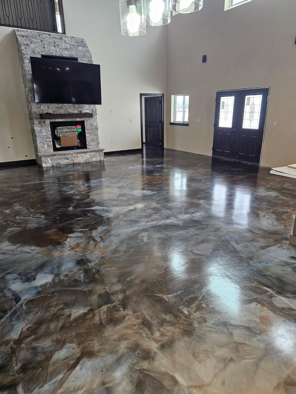 A living room with a shiny metallic floor and a fireplace.