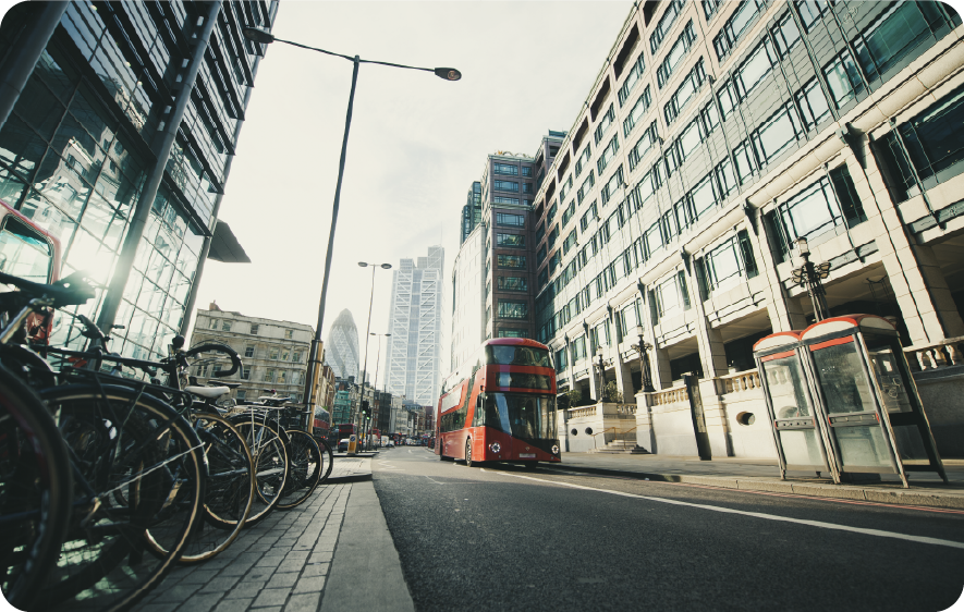 A red double decker bus is driving down a city street.