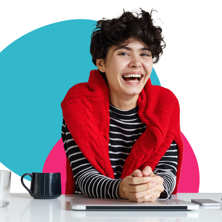 A woman wearing a red scarf is sitting at a desk with a laptop