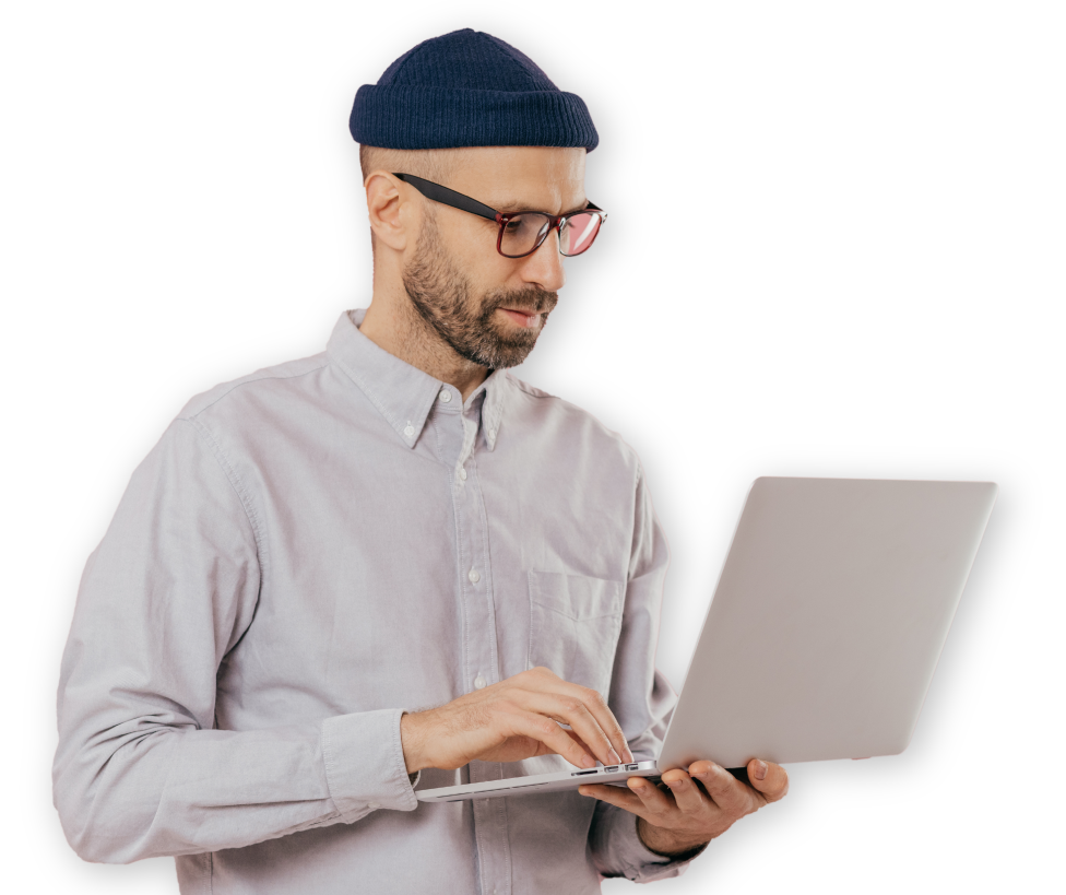 A man wearing glasses and a beanie is using a laptop computer.