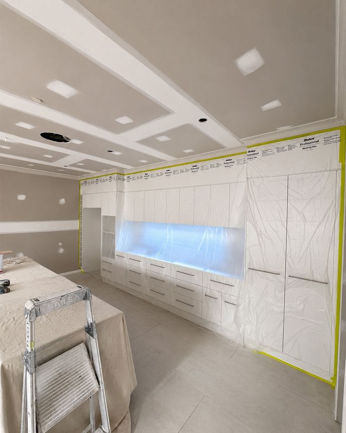 Bright, empty modern room with wood floors, white walls, ceiling fan, and tall windows.