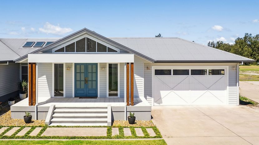 Modern single-story house with white siding, front porch, and attached two-car garage