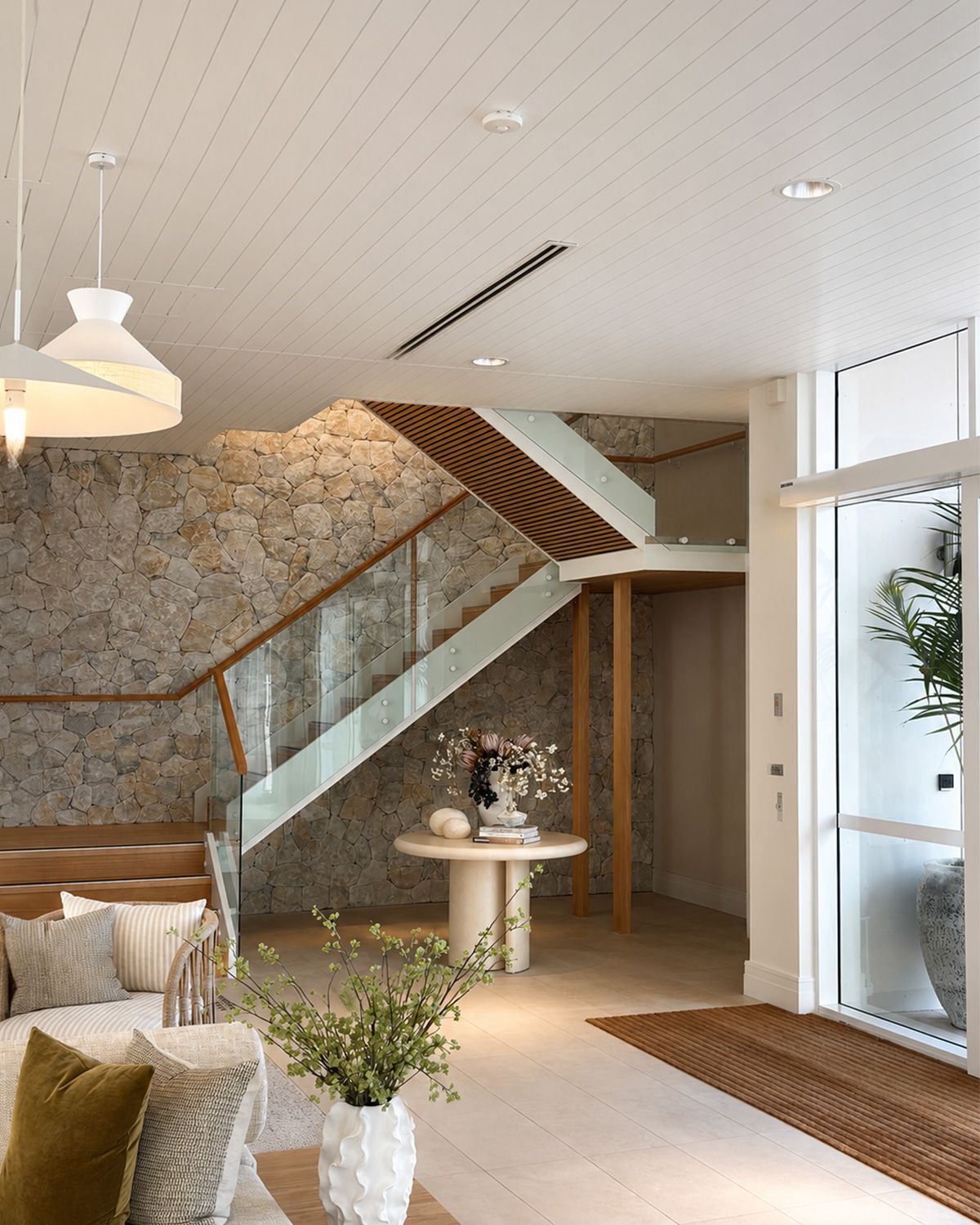 Bright, empty modern room with wood floors, white walls, ceiling fan, and tall windows.
