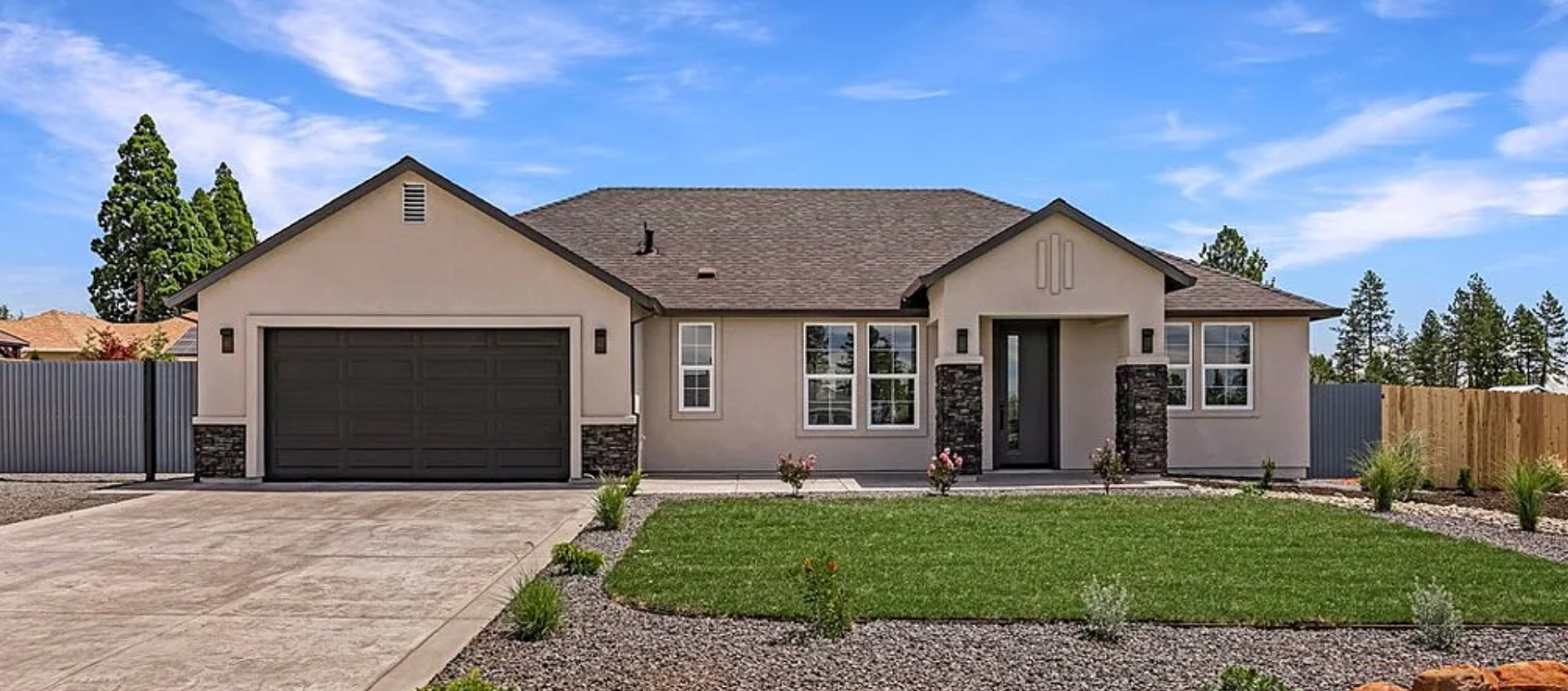 Single-story beige house with a two-car garage, driveway, and front lawn
