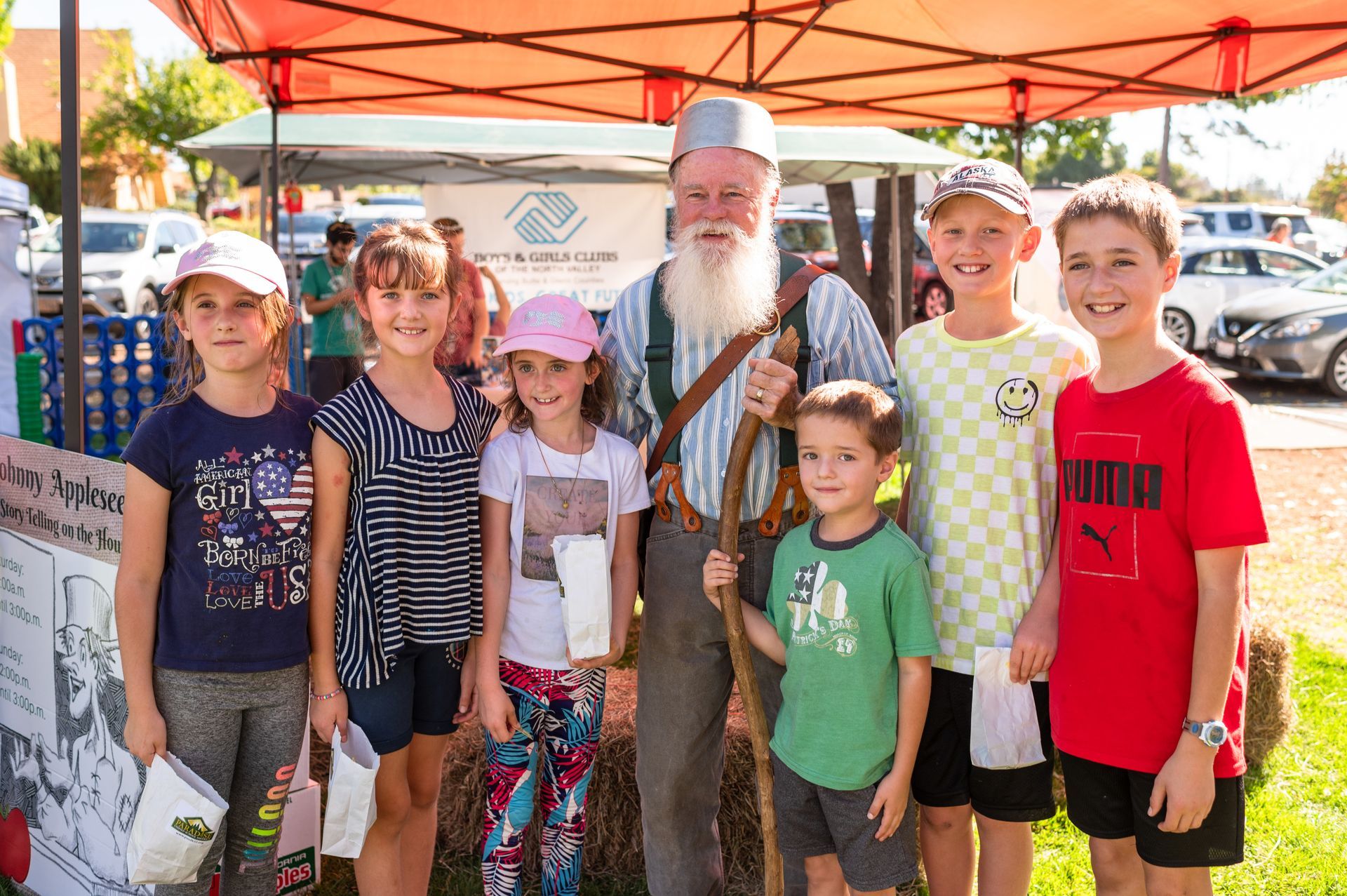Johnny Appleseed posing for a photo with local youth
