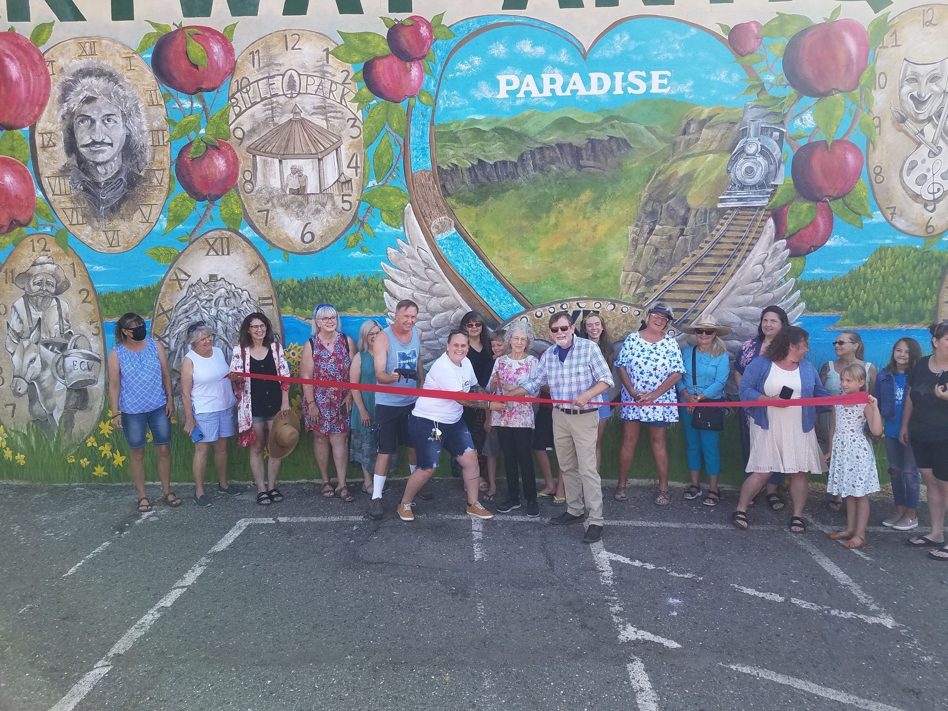 A group of people standing in front of a mural that says paradise