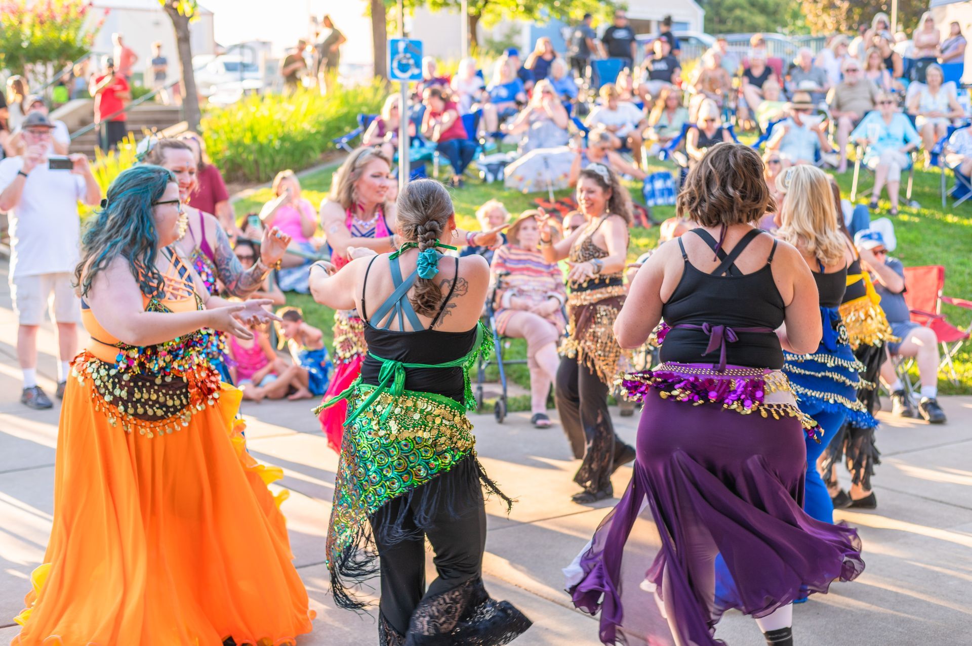 A group of women are dancing in front of a crowd of people in Paradise and Magalia, California