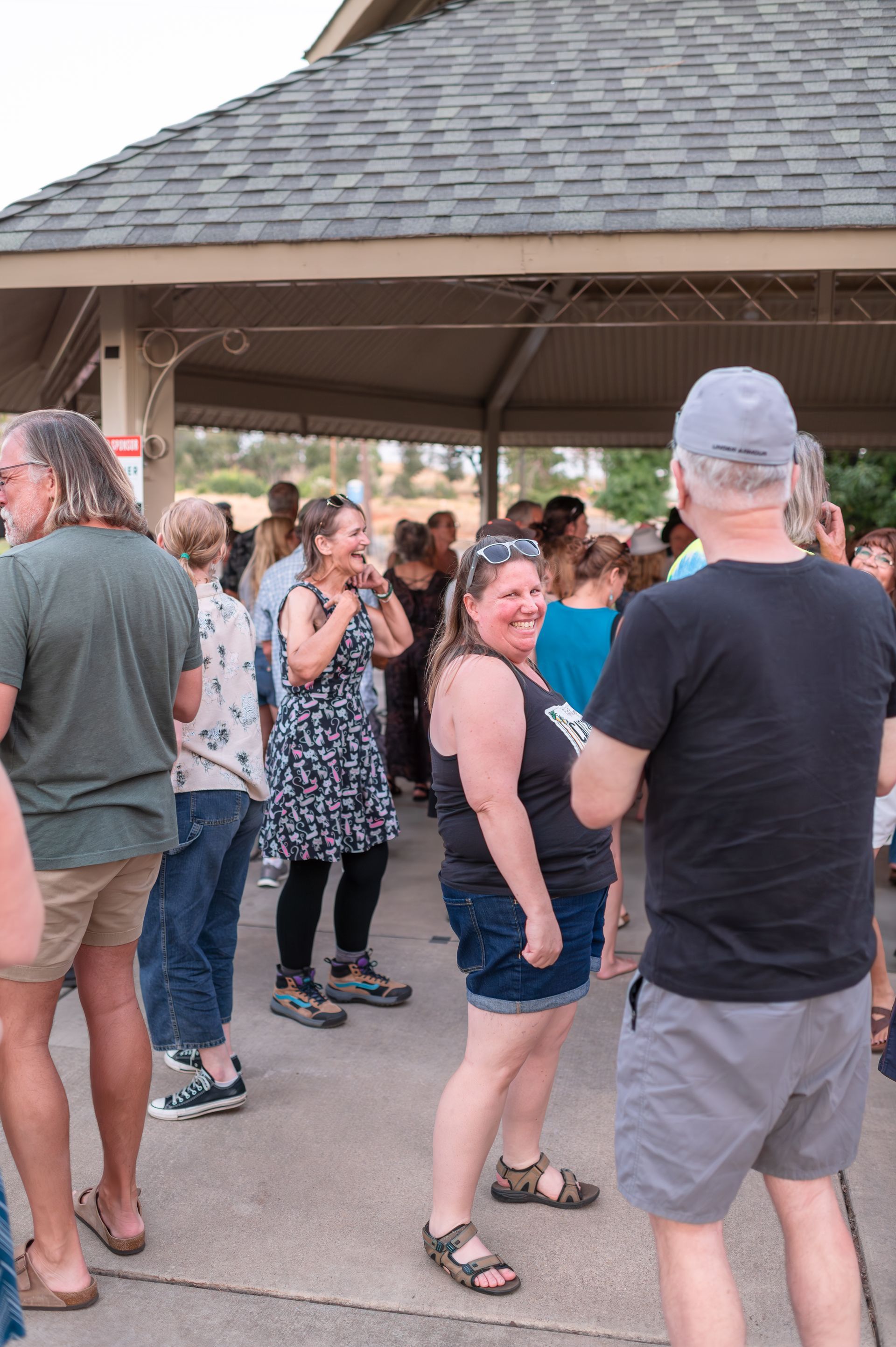 A group of people are standing under a pavilion.
