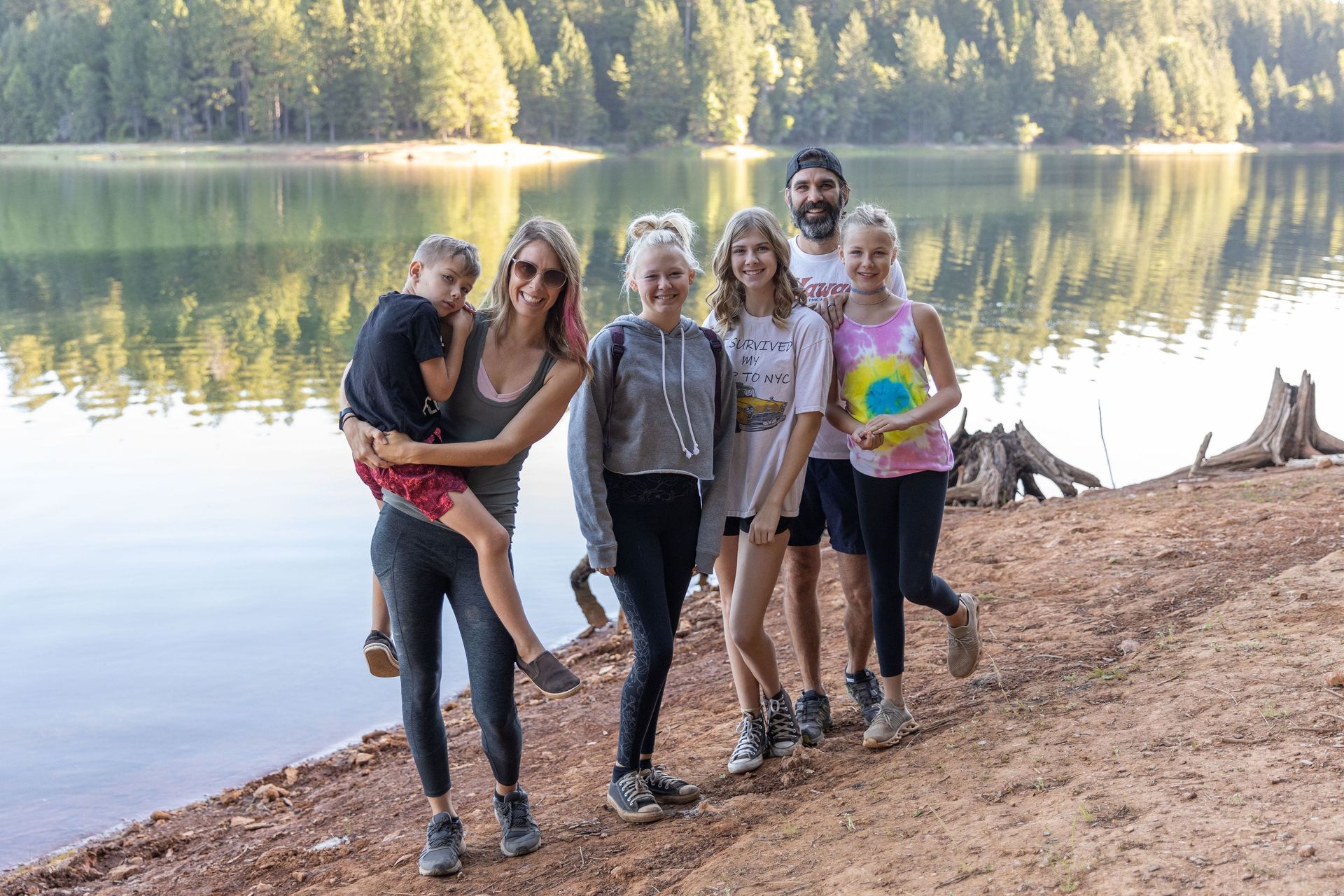 A group of people are posing for a picture on the shore of paradise lake.