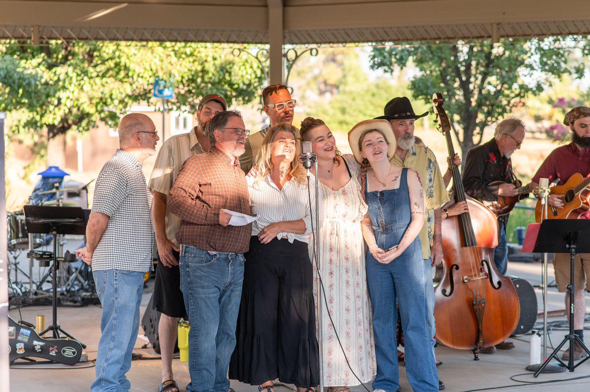 Theatre on the Ridge cast performing a preview of Radioland Paradise. Actors and actresses singing into a microphone while musicians play instruments