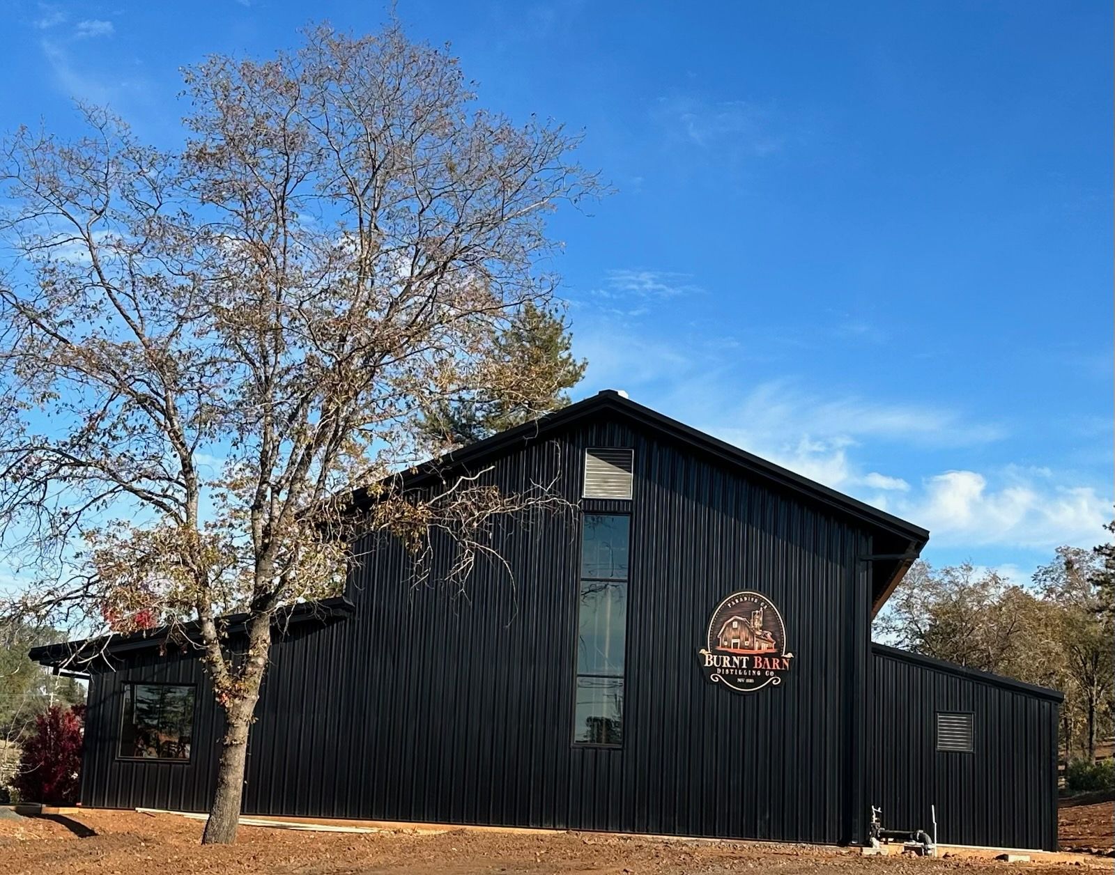 A large black building with a tree in front of it.