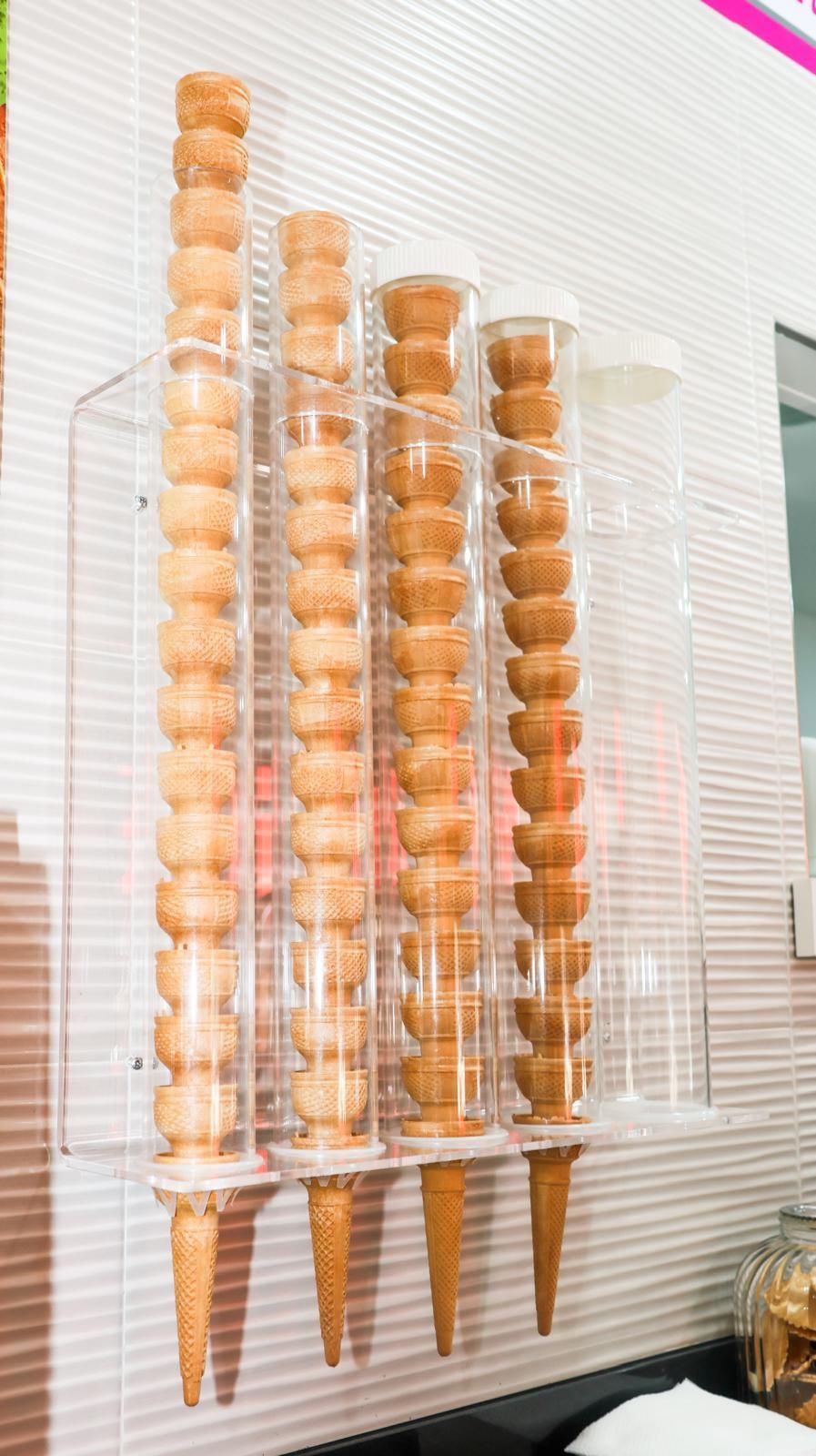 Una fila di coni gelato impilati uno sopra l'altro su un muro.