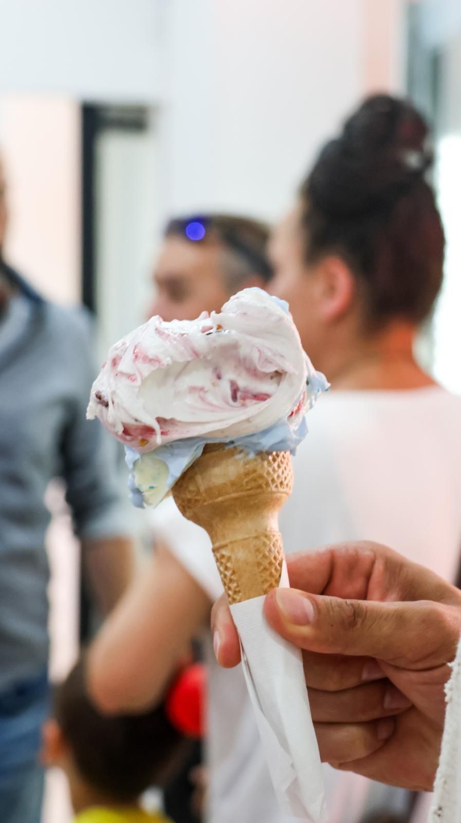 Una persona tiene in mano un cono gelato.