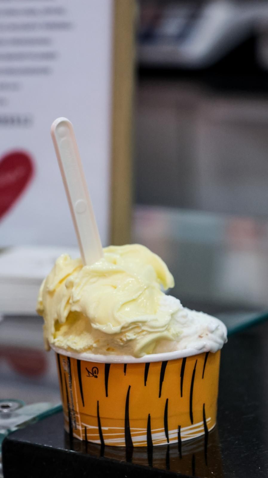 Una coppa di gelato con un cucchiaino dentro su un tavolo.