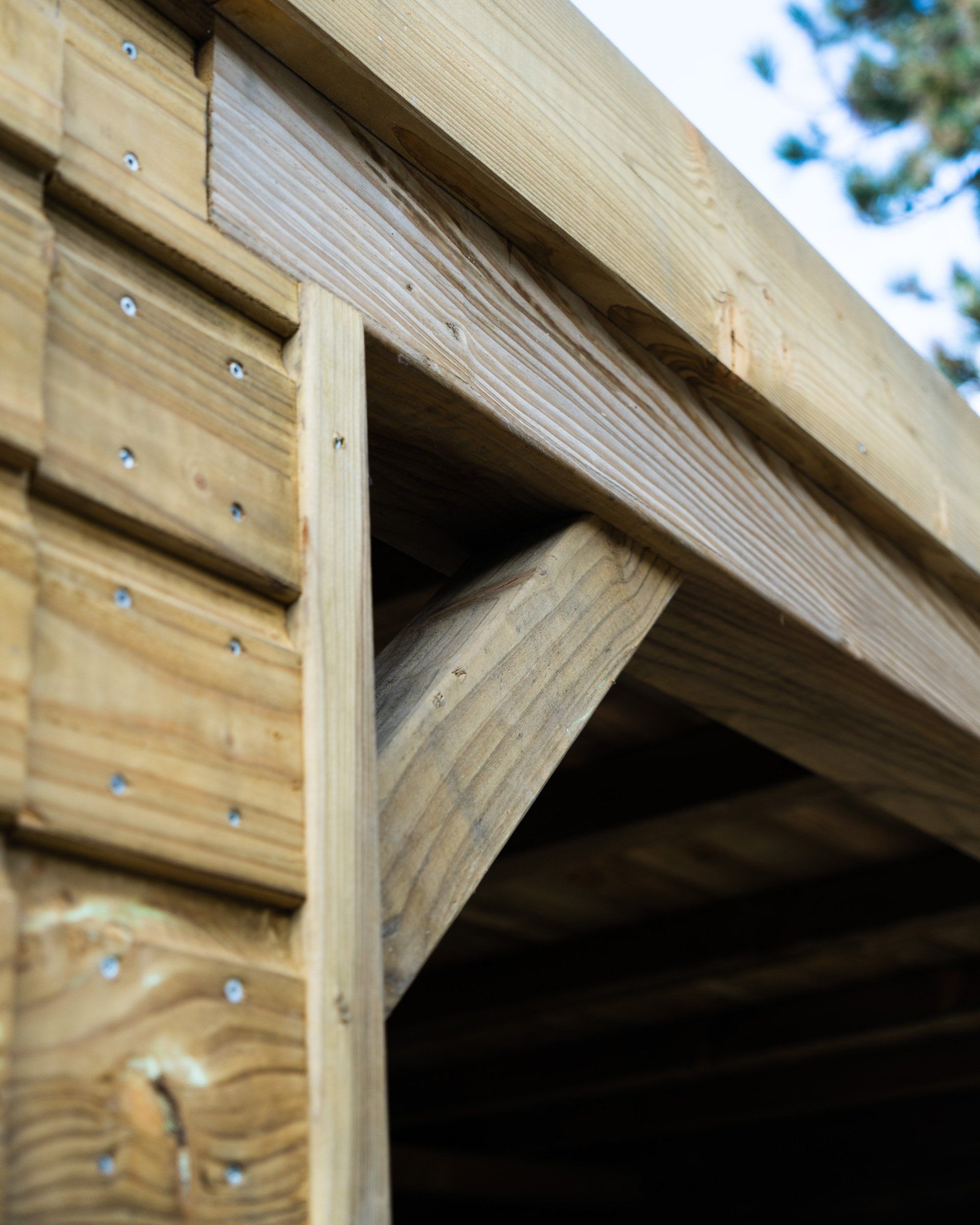 Houten schuurframe met steunbalken en zijwanden.