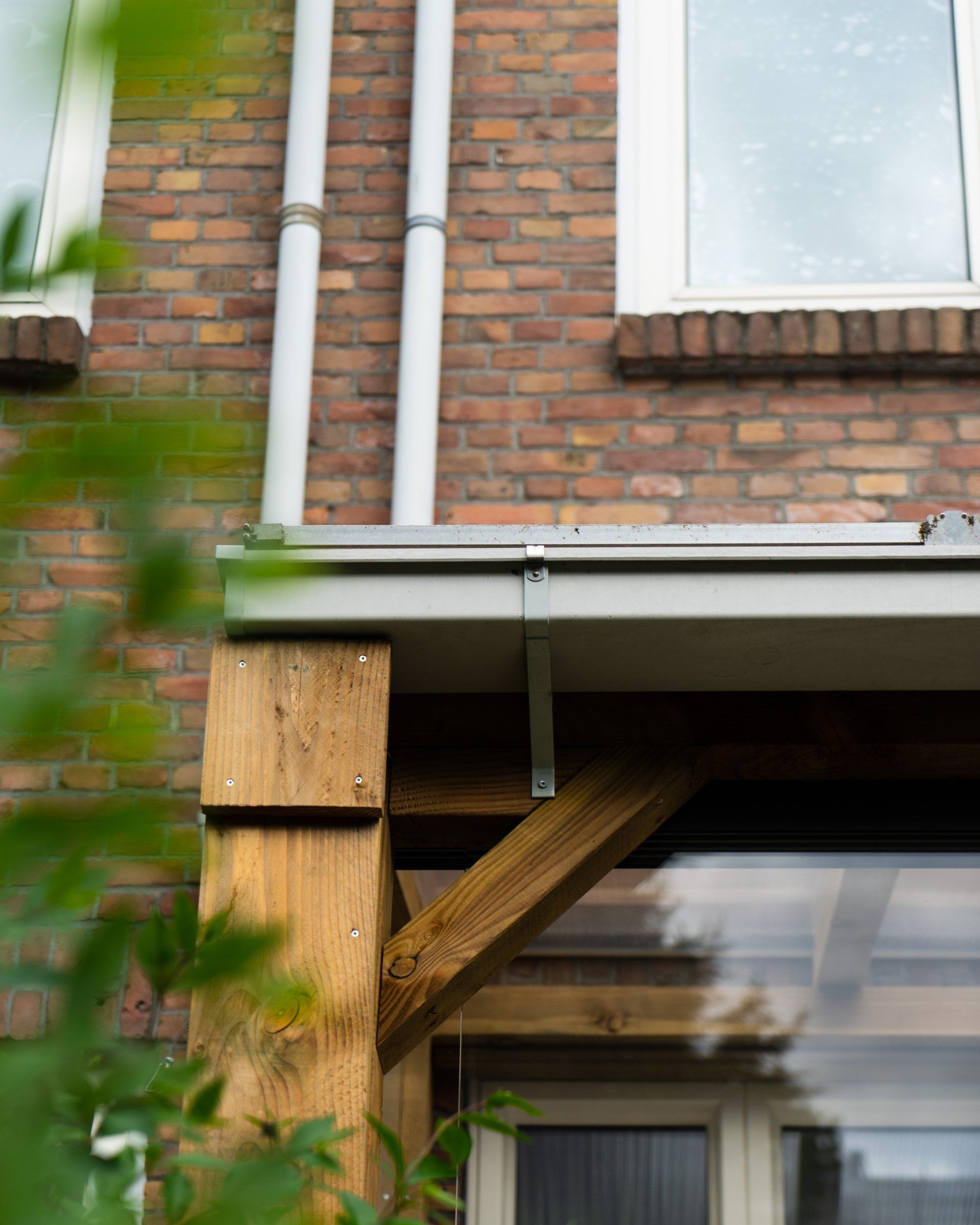 De buitenkant van het gebouw is opgetrokken uit baksteen, met houten steunbalken, witte goten en twee verticale pijpen.