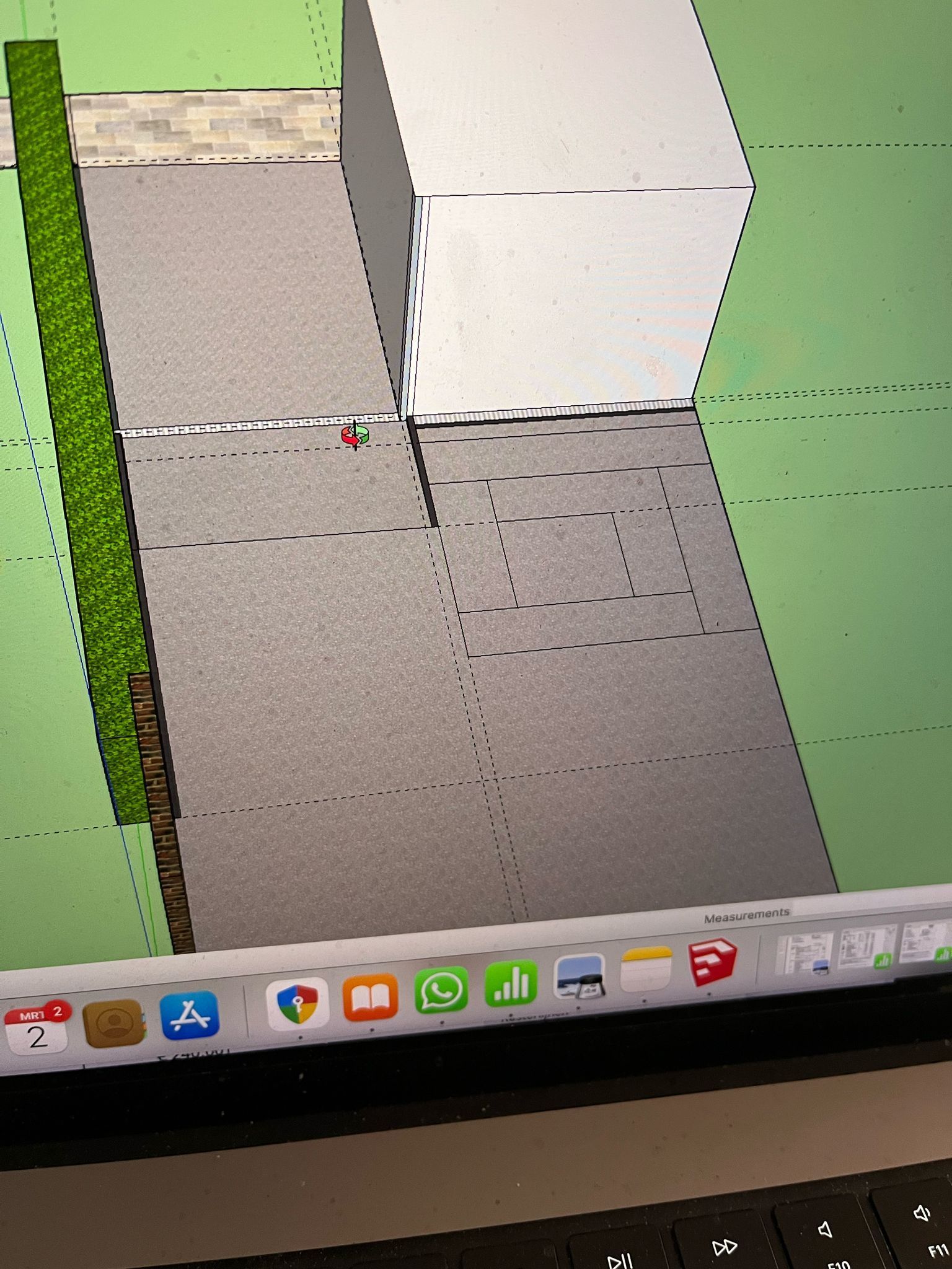3D-model van een gebouw met een grijze gevel, grenzend aan een grijs bestraat gebied en een groene heg.
