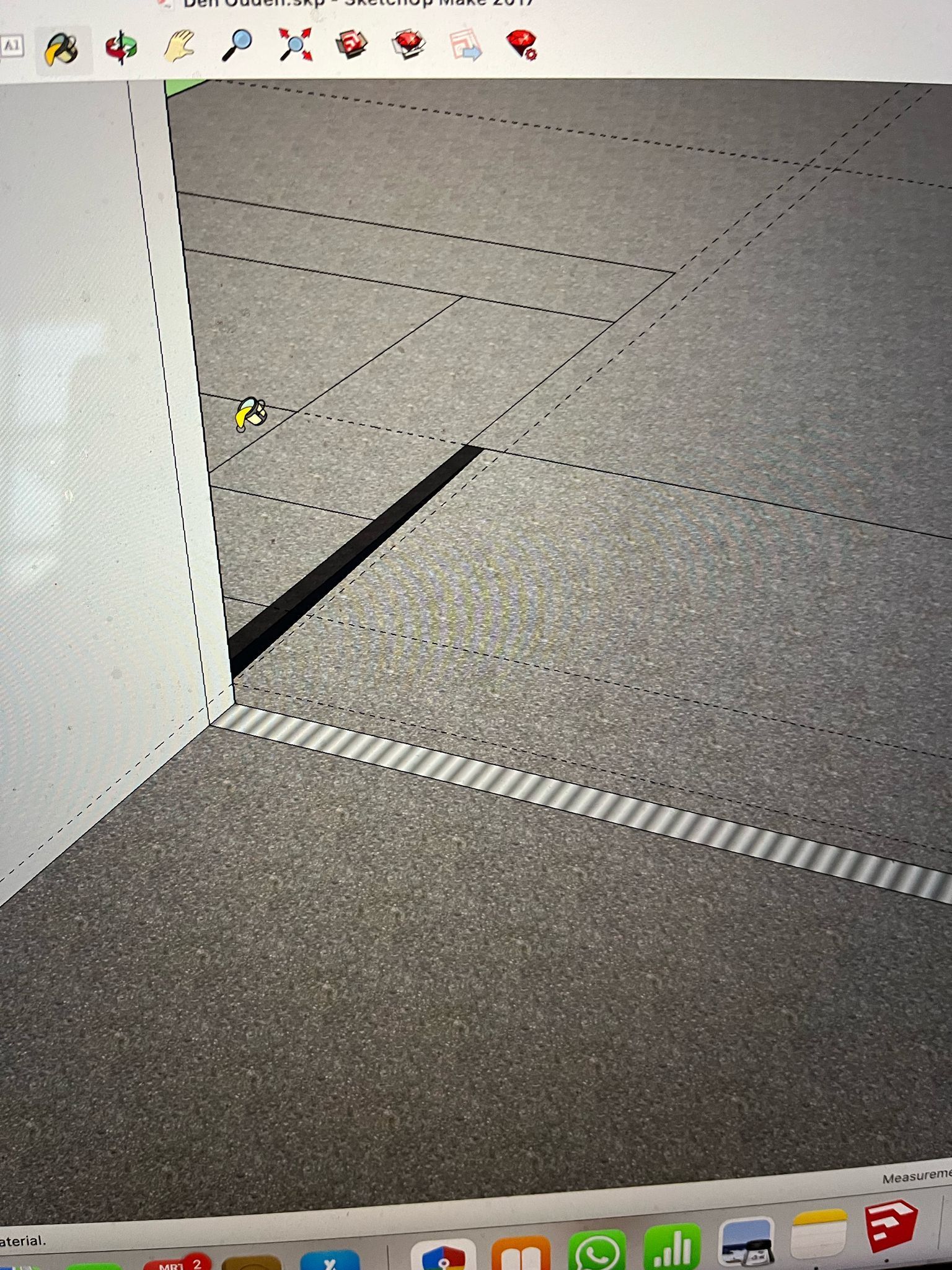 Detailopname van een gestructureerd grijs oppervlak met witte lijnen en een zwarte schaduw, geworpen door een witte, schuine muur.